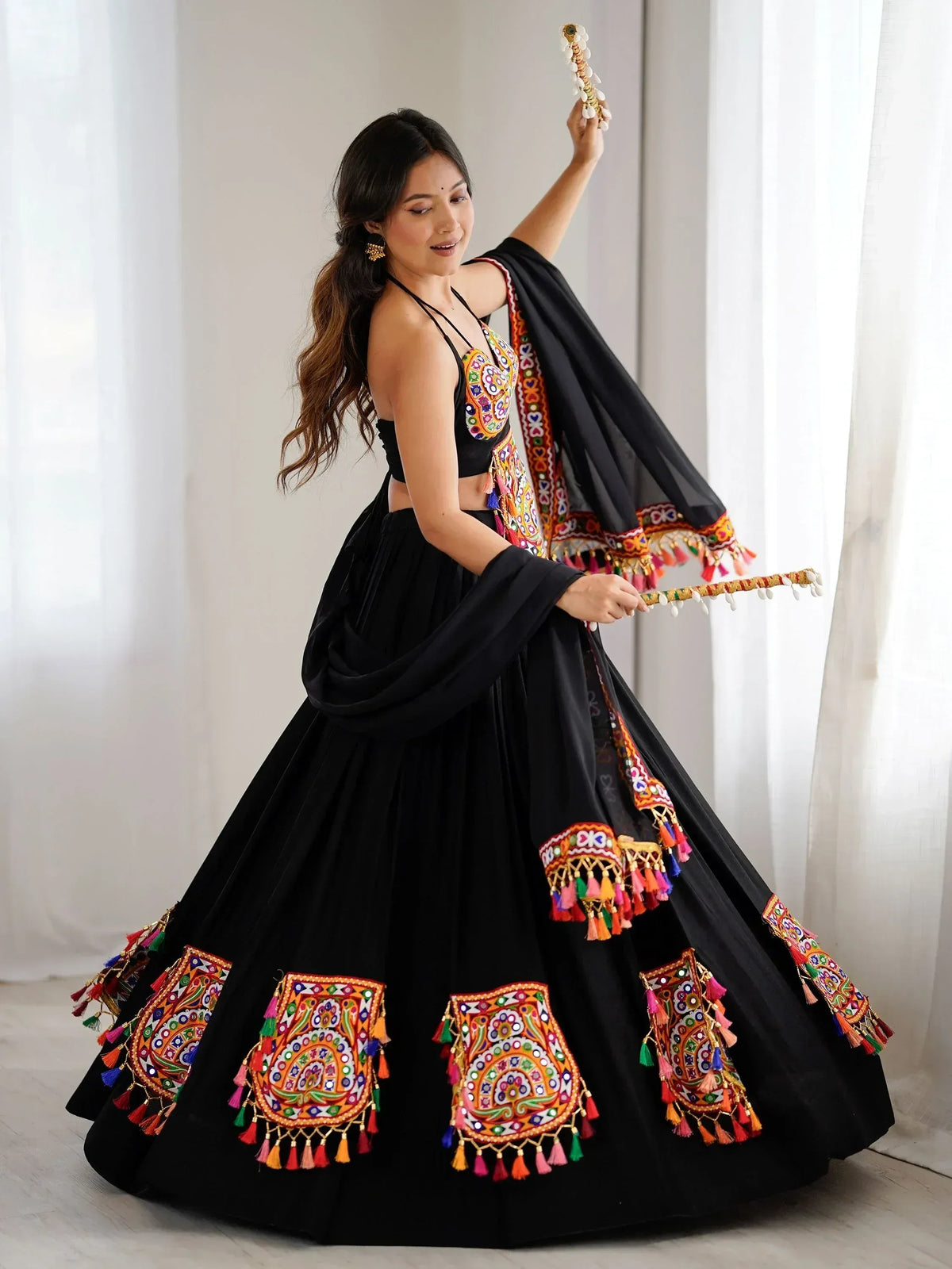 Black embroidered lehenga choli with colorful mirror work and tassels, perfect for Indian ethnic wear