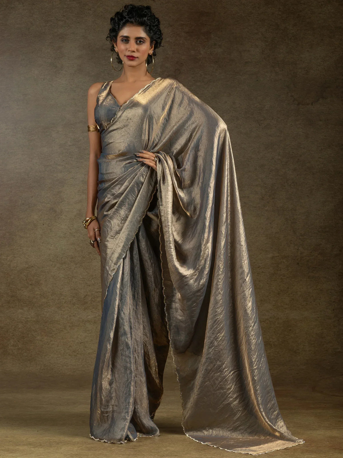 Elegant metallic grey saree with gold trim, styled for Indian ethnic wear occasions