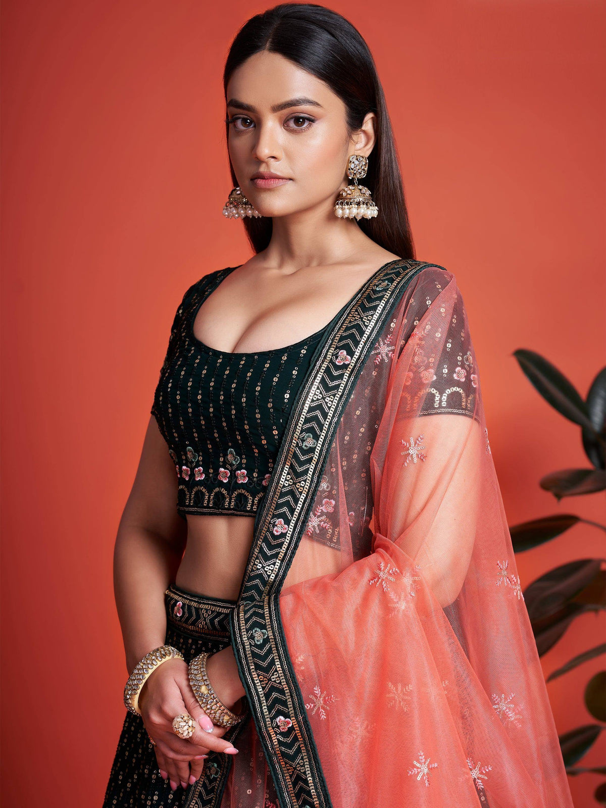 Woman in black embroidered lehenga choli with peach net dupatta, traditional Indian ethnic wear