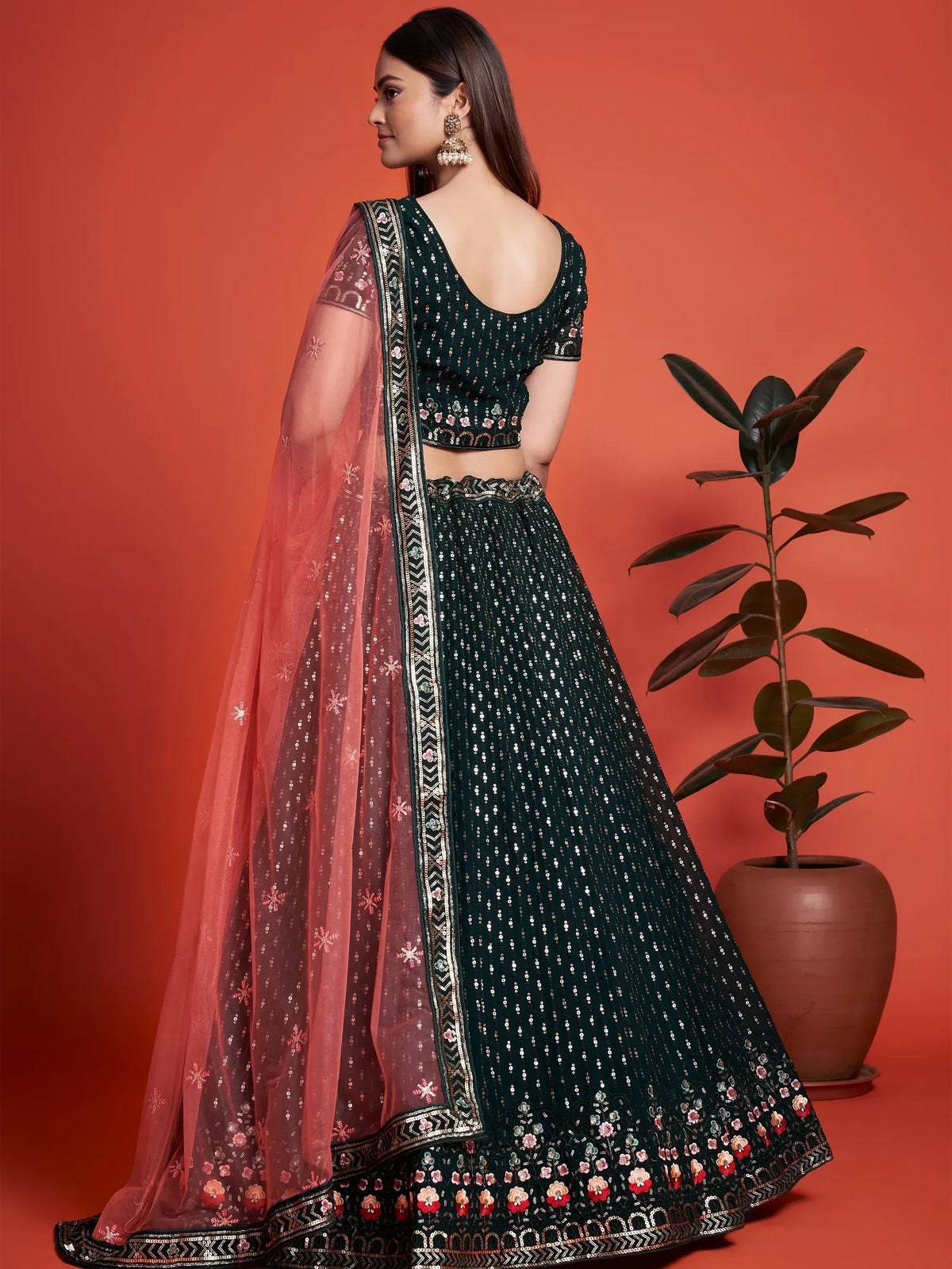 Emerald green sequin lehenga choli with floral embroidery and sheer pink dupatta, perfect for Indian weddings and festive occasions.