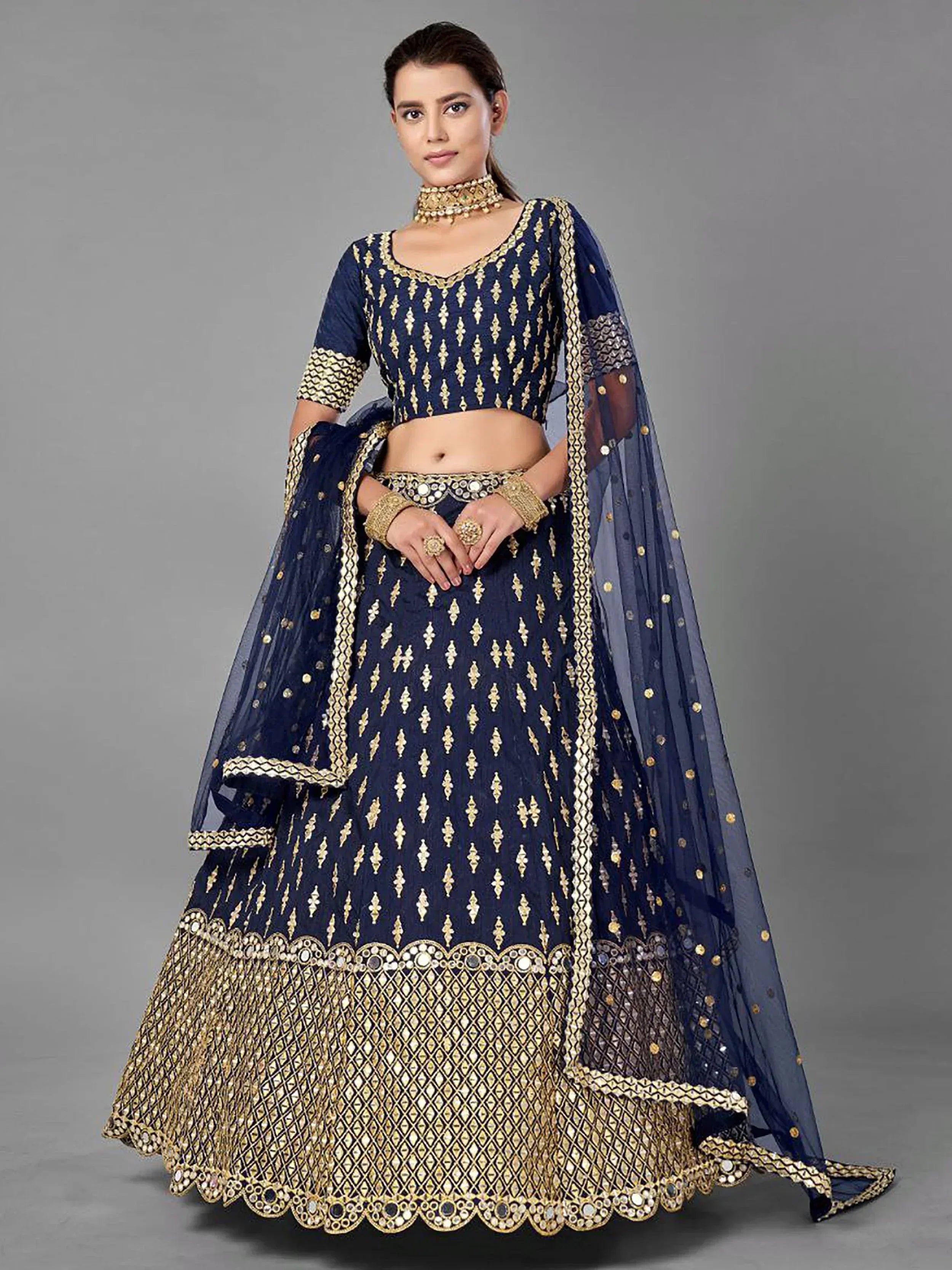 Navy blue designer lehenga choli with gold embroidery and mirror work, perfect for weddings and festive occasions.