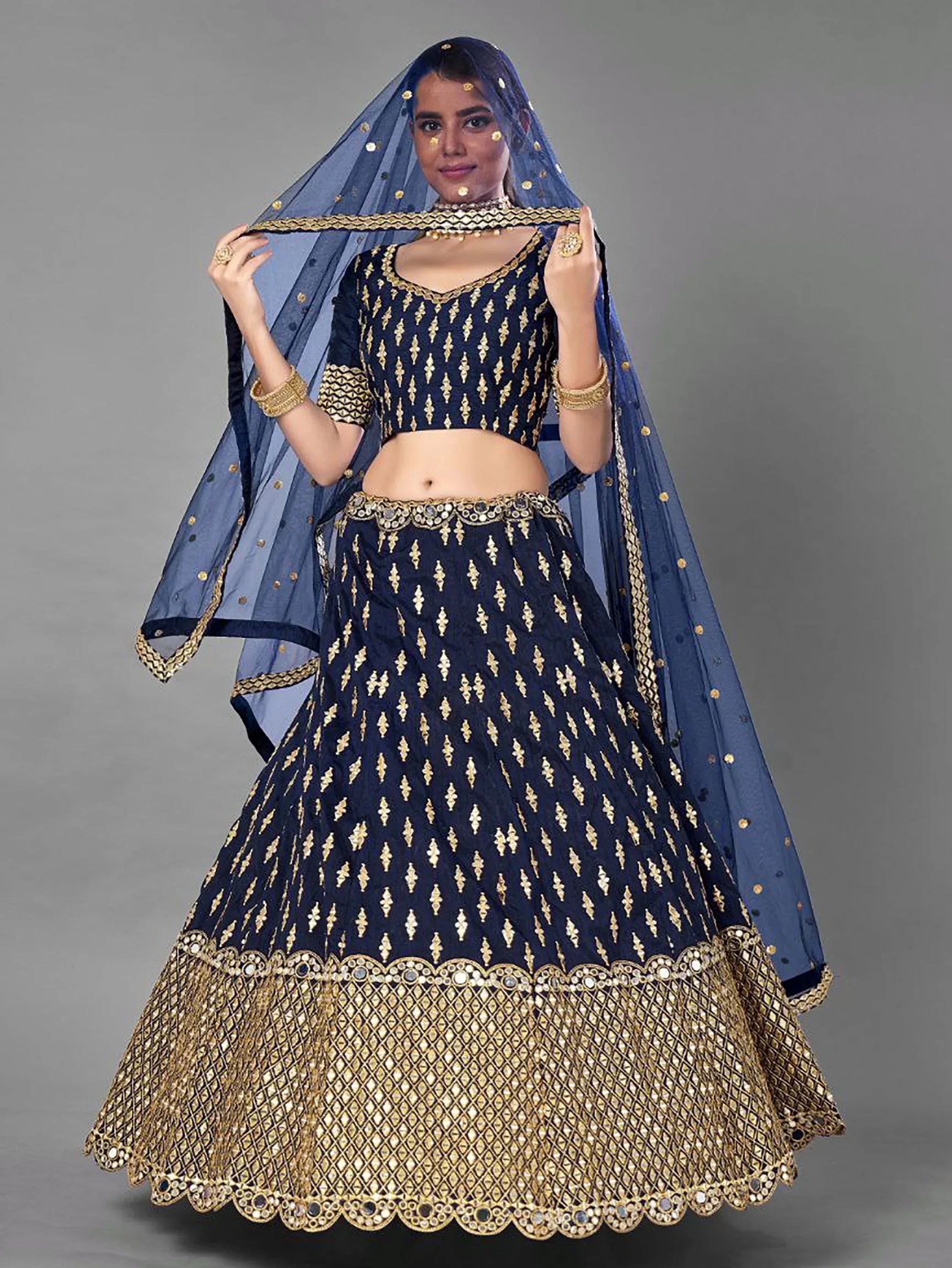 Navy blue lehenga choli with gold embroidery and mirror work, paired with matching dupatta for Indian ethnic wear