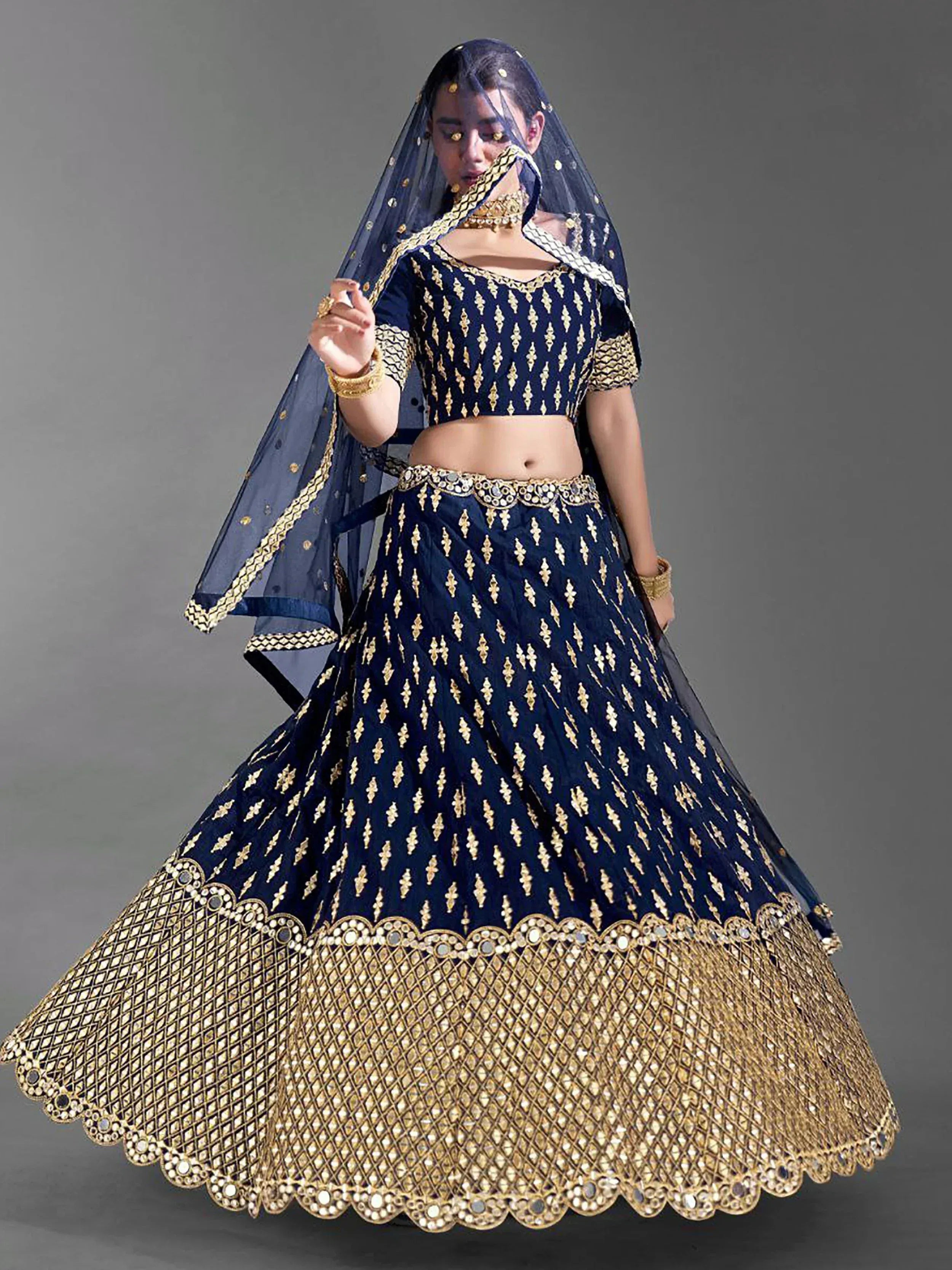 Navy blue lehenga choli with gold embroidery and mirror work, perfect for Indian weddings and festive occasions.