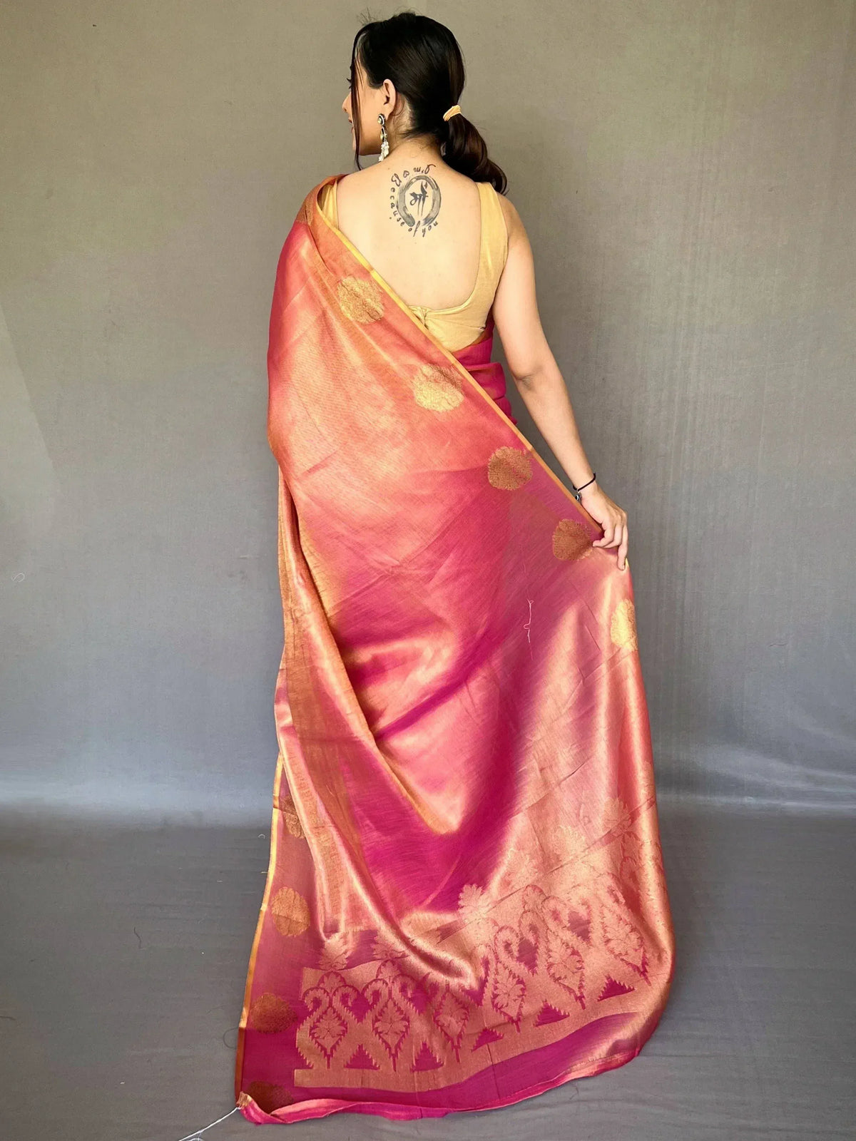 Pink and gold designer saree with floral motifs, paired with yellow blouse, ideal for ethnic occasions