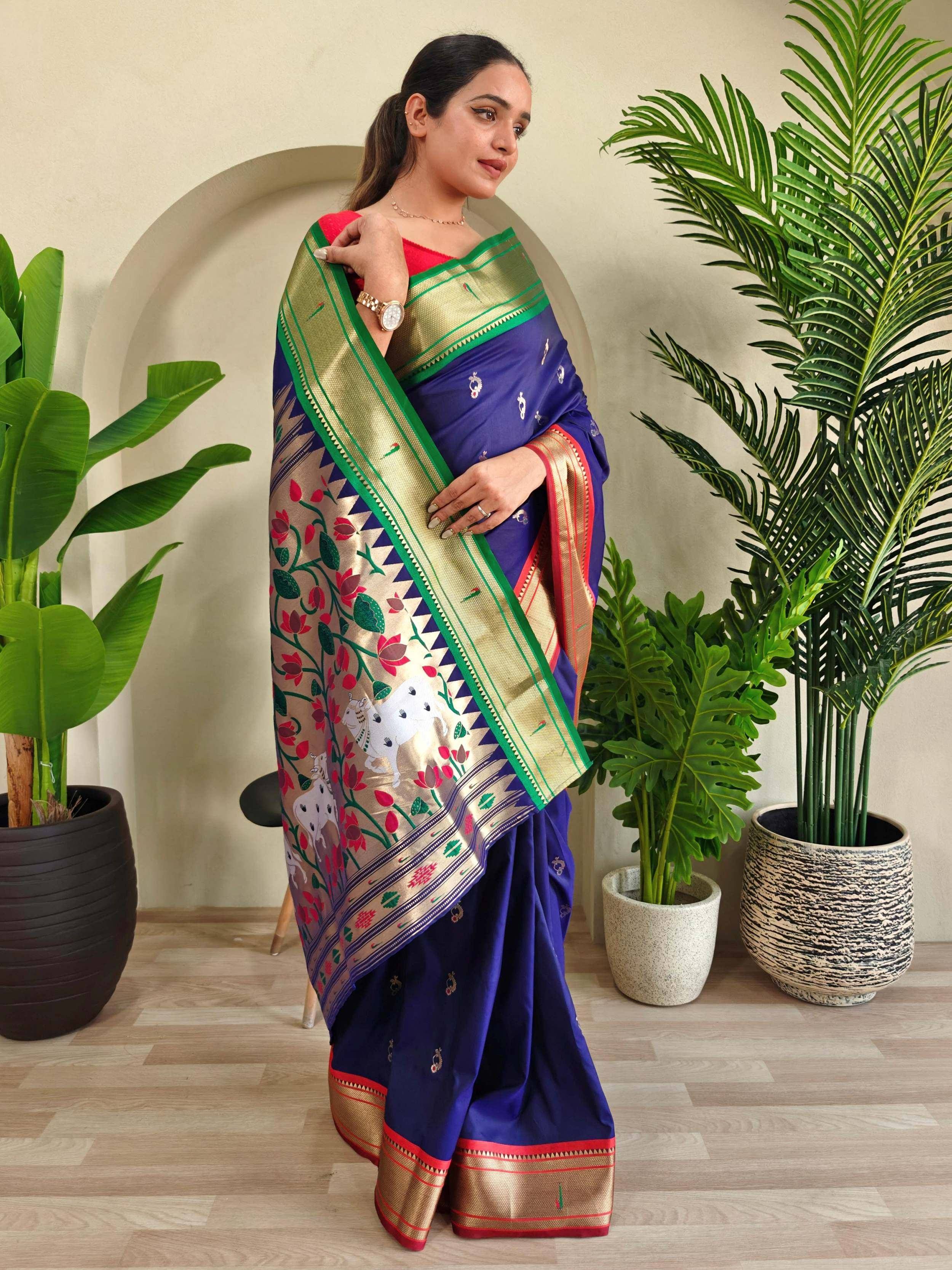 Woman in blue designer saree with floral and elephant motifs, gold border, red blouse, perfect for ethnic occasions
