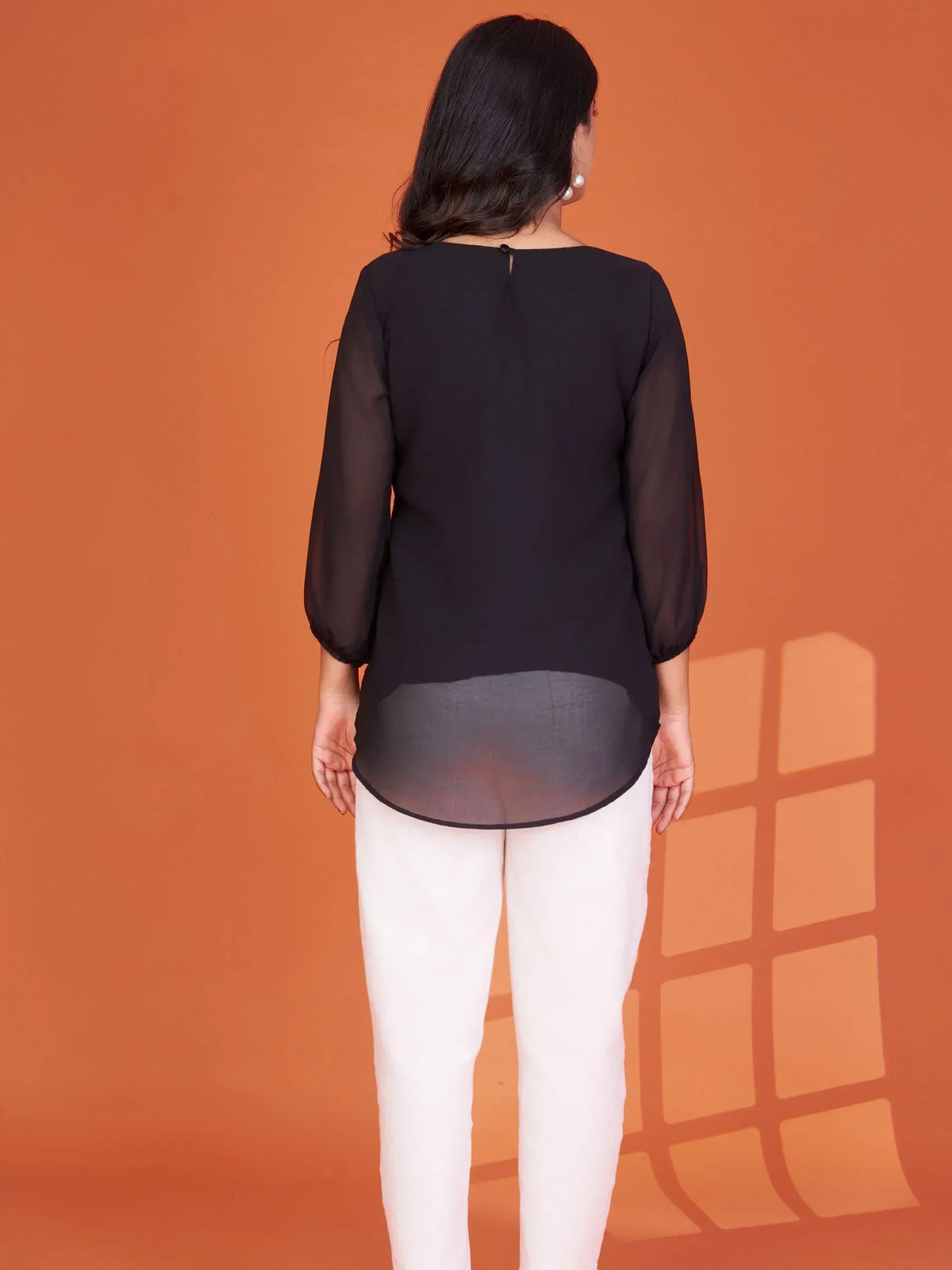 Black sheer top with white pants, back view, ethnic wear style