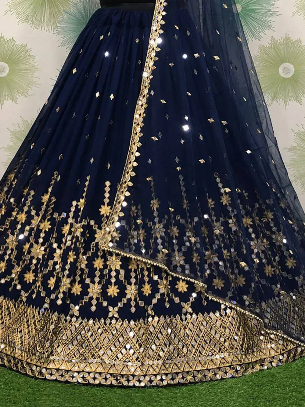 Navy blue lehenga with gold floral embroidery and mirror work, ideal for Indian ethnic wear events.