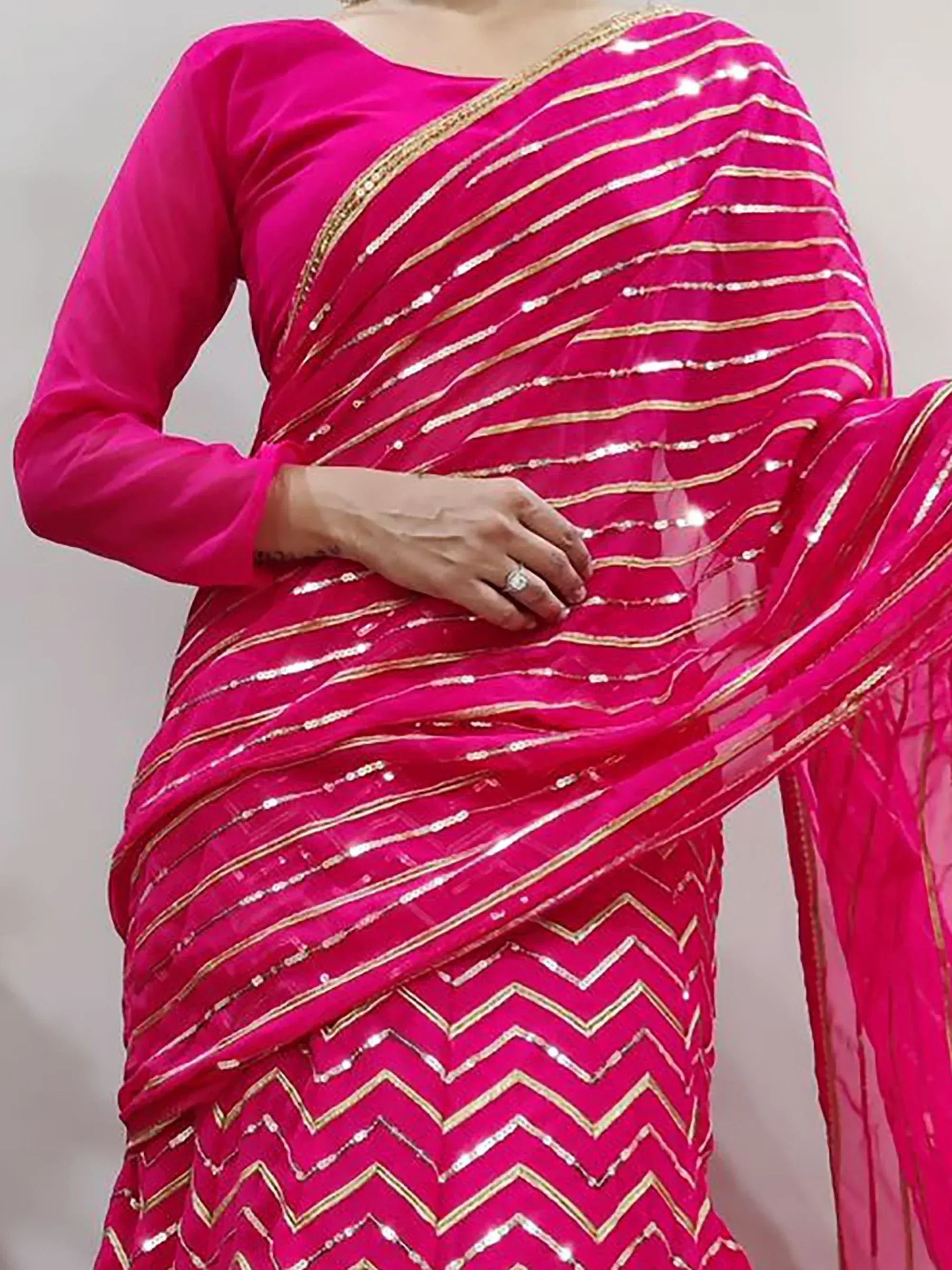 Vibrant pink saree with gold sequin stripes and chevron border, perfect for Indian ethnic wear occasions
