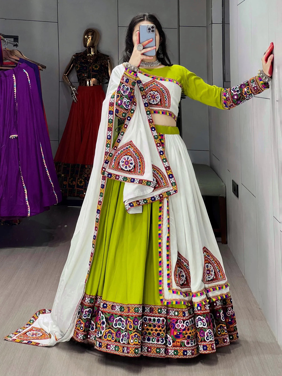 Woman in vibrant green and white embroidered lehenga choli with mirror work, perfect for Indian ethnic wear.