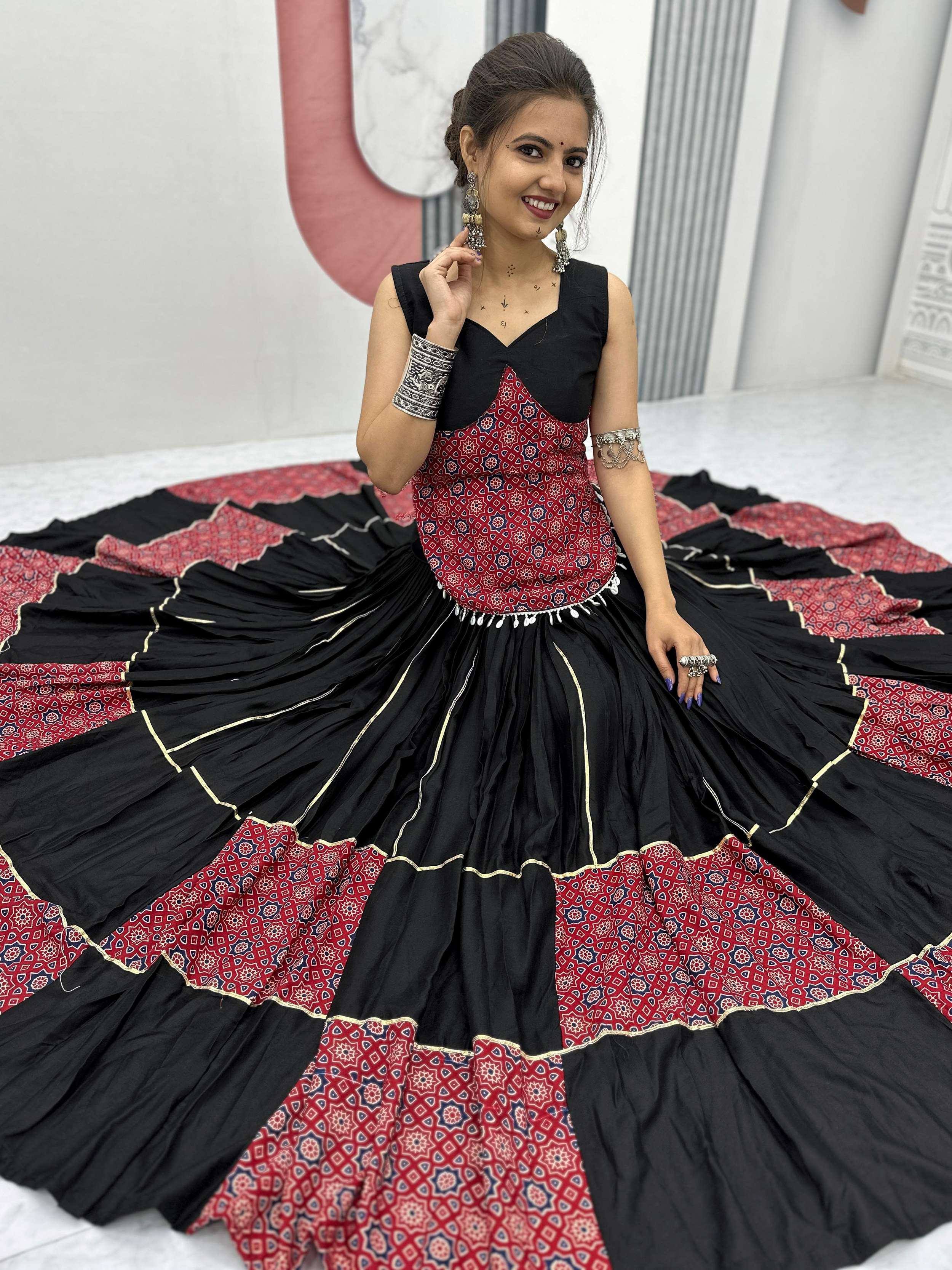 Woman in black and red printed ethnic gown with flared skirt, perfect for Indian festive occasions.