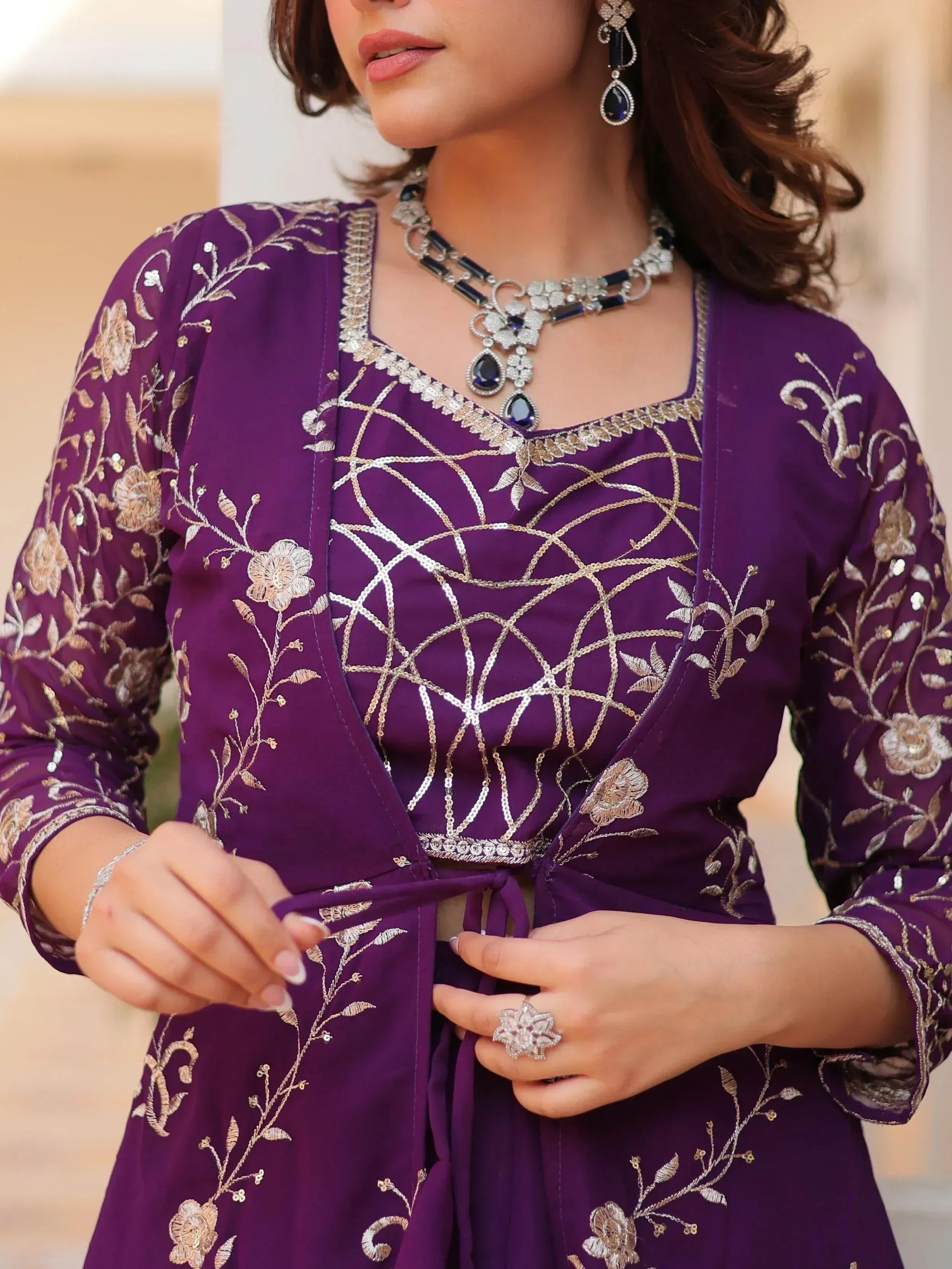 Purple ethnic kurti with gold floral embroidery and sequin detailing, paired with statement jewelry