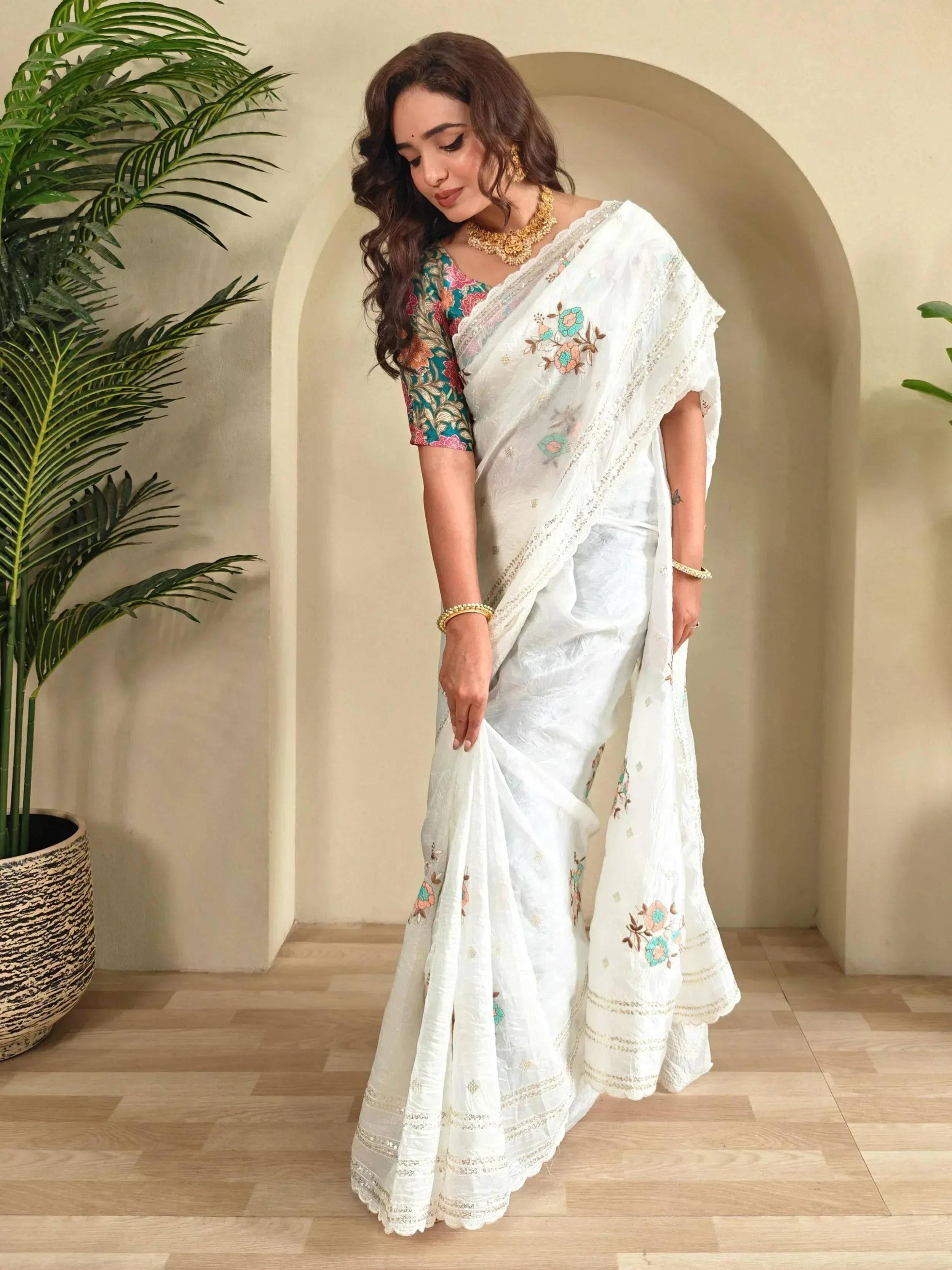 White embroidered saree with floral design and colorful blouse, perfect for ethnic occasions