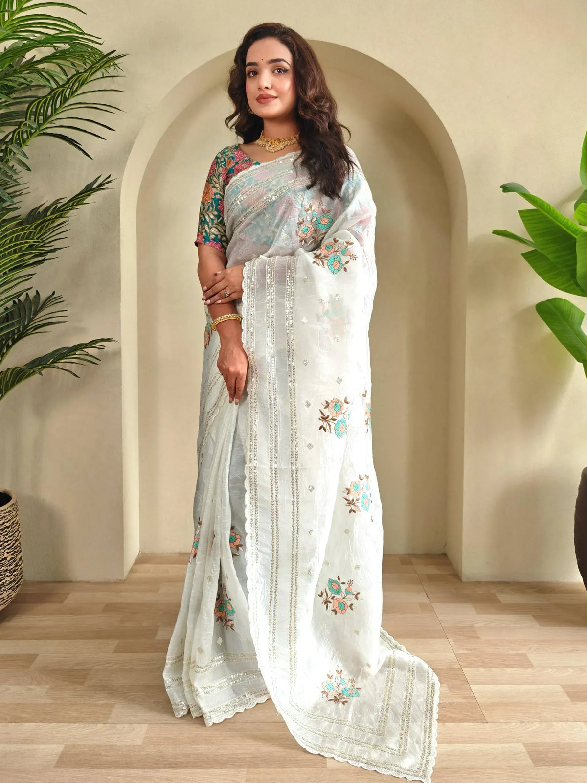 Woman in elegant white floral embroidered saree with sequin border, perfect for Indian ethnic occasions