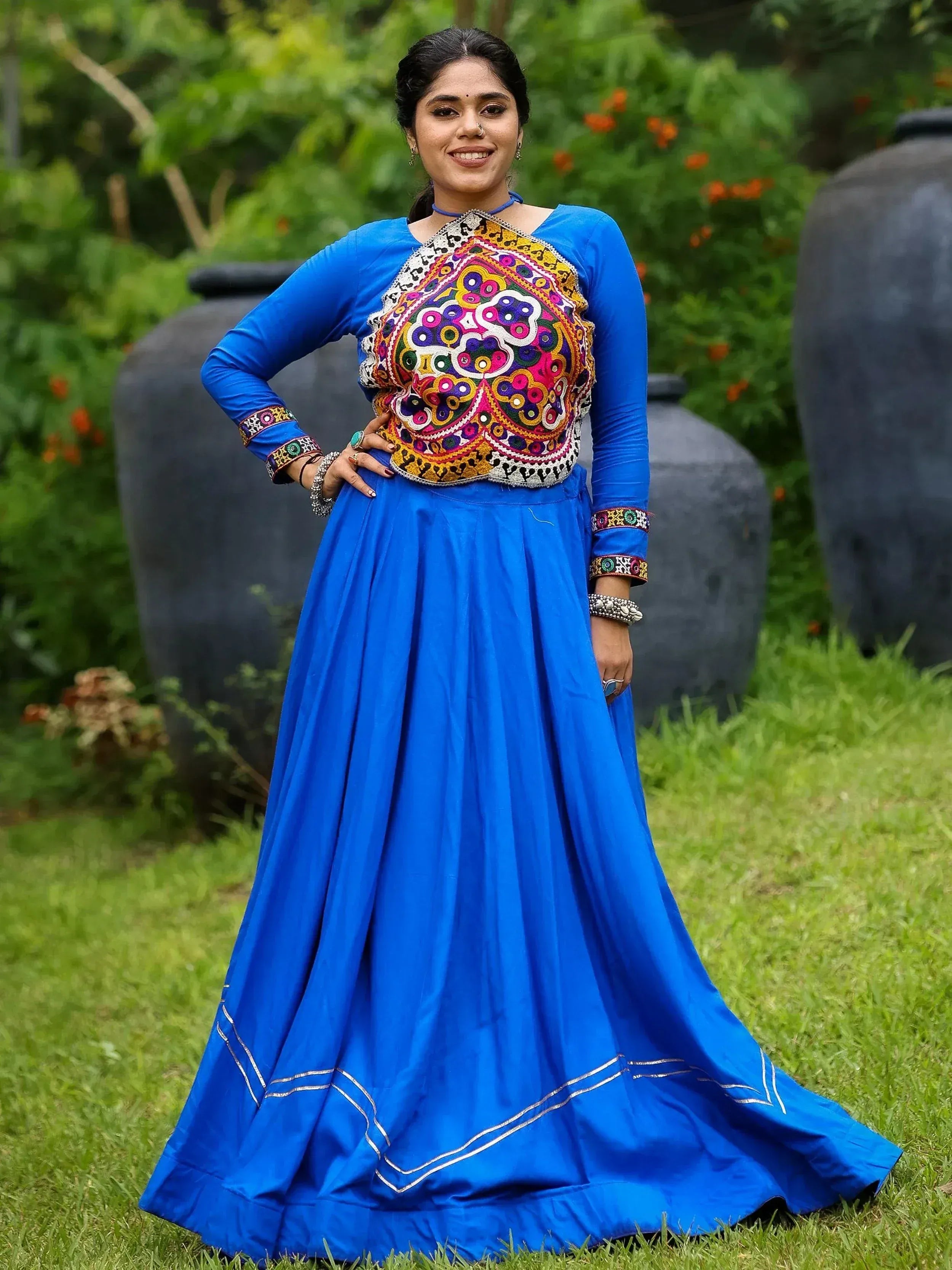 Woman in vibrant blue ethnic gown with colorful embroidered blouse, perfect for Indian occasions