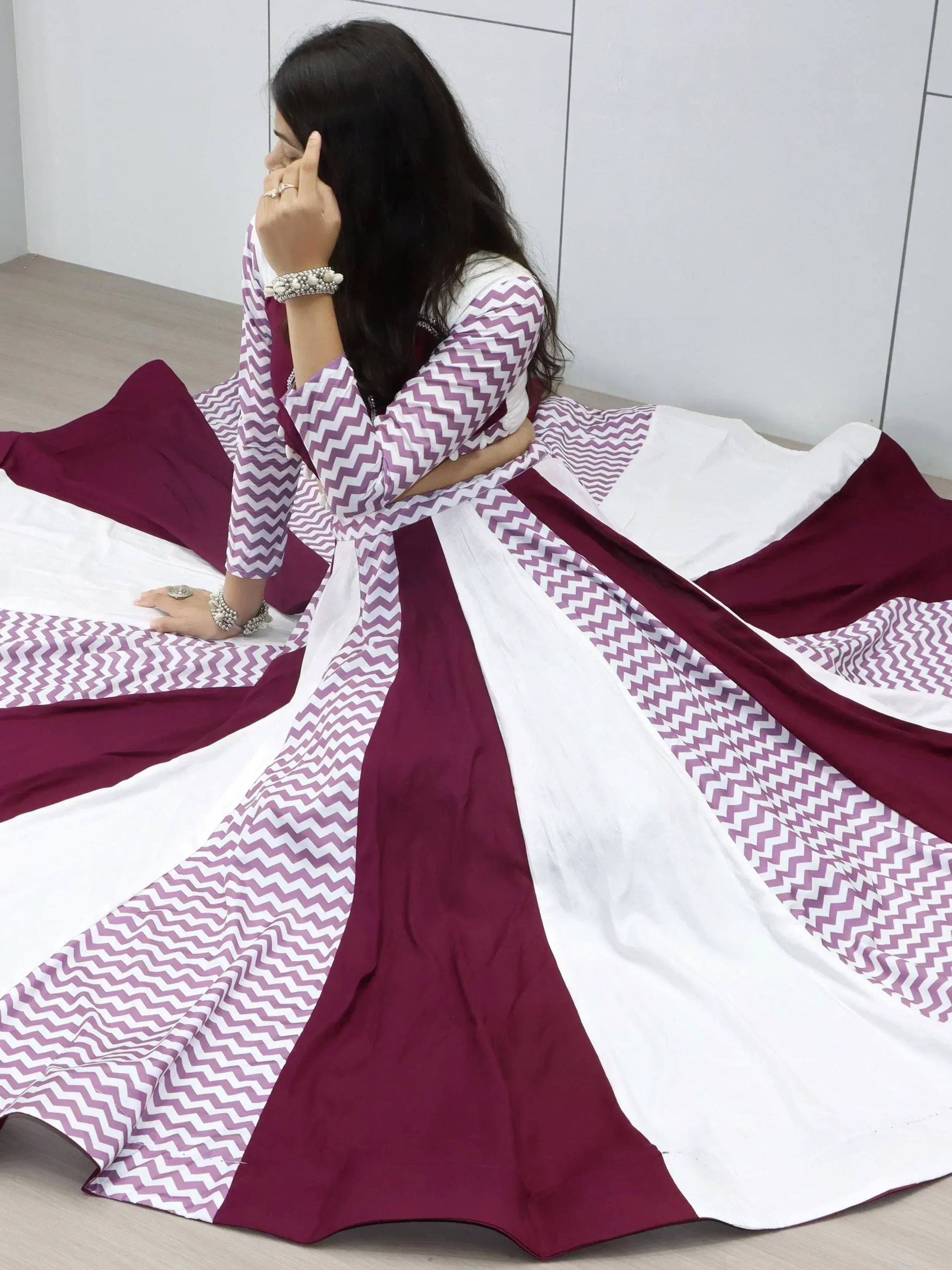 Woman in maroon and white chevron print ethnic gown, Indian designer wear