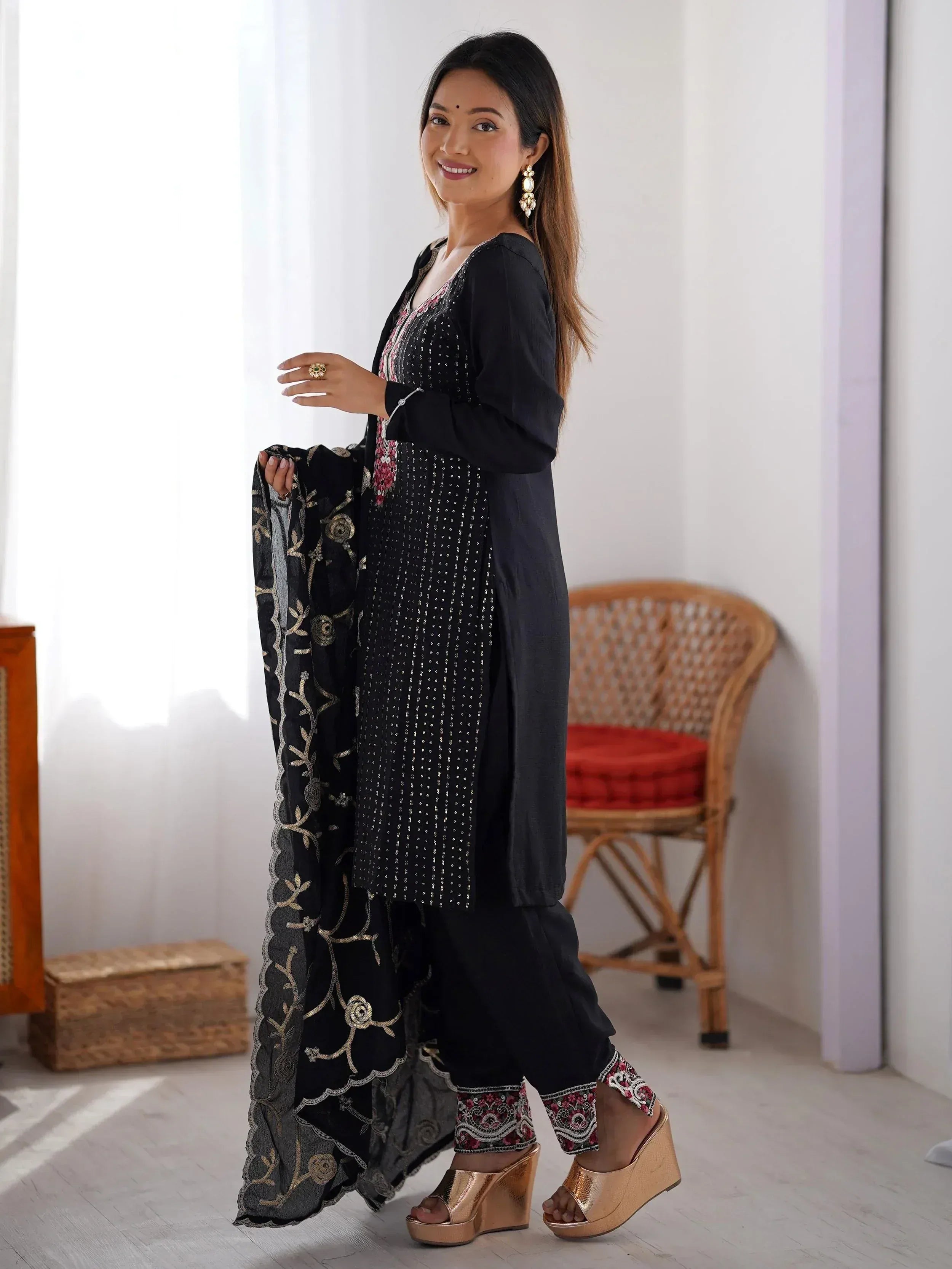 Black embroidered salwar kameez with gold detailing, paired with matching dupatta and gold heels for ethnic wear.