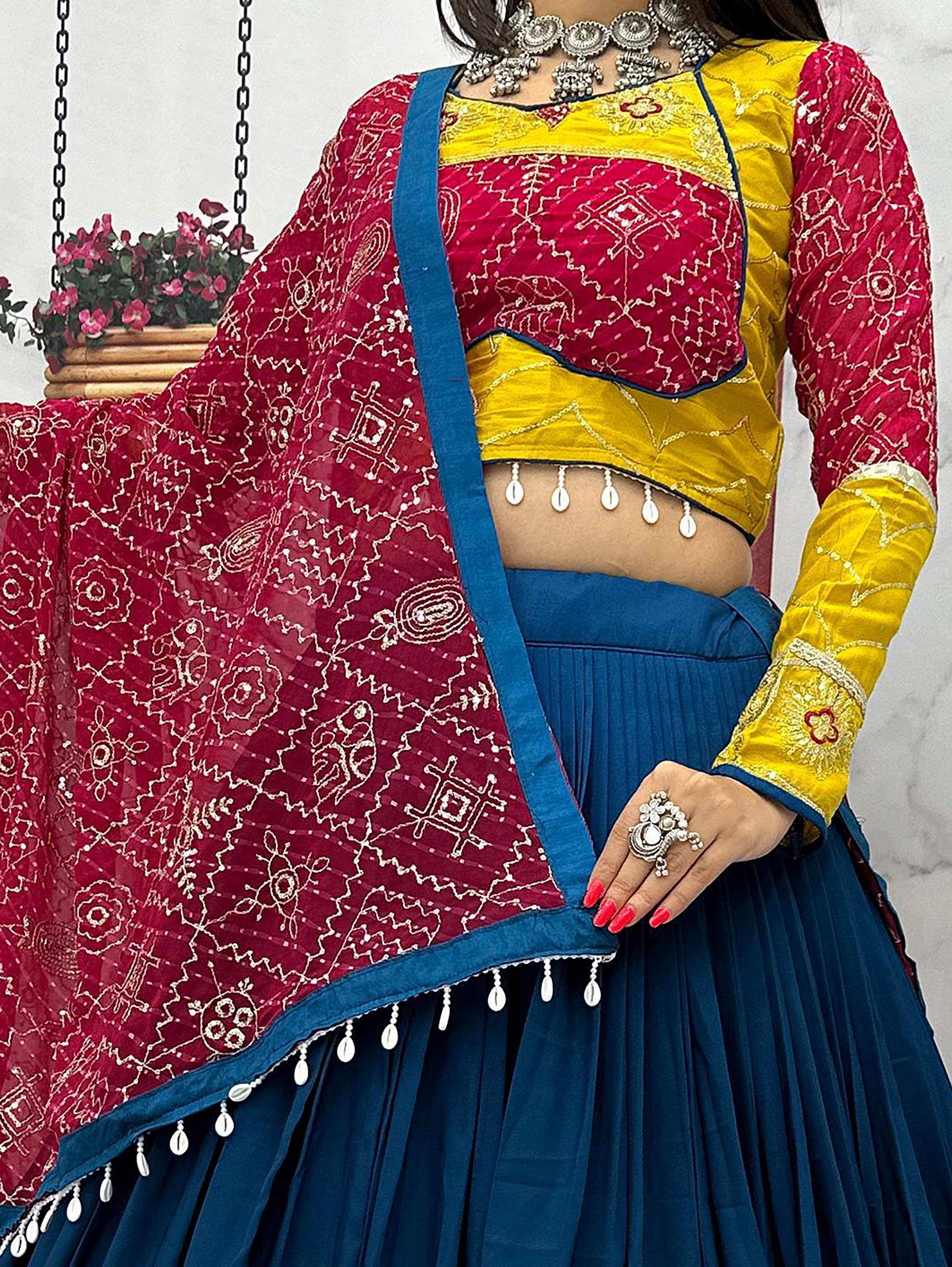 Vibrant Indian ethnic lehenga choli with red and yellow embroidered top, blue pleated skirt, and matching dupatta.