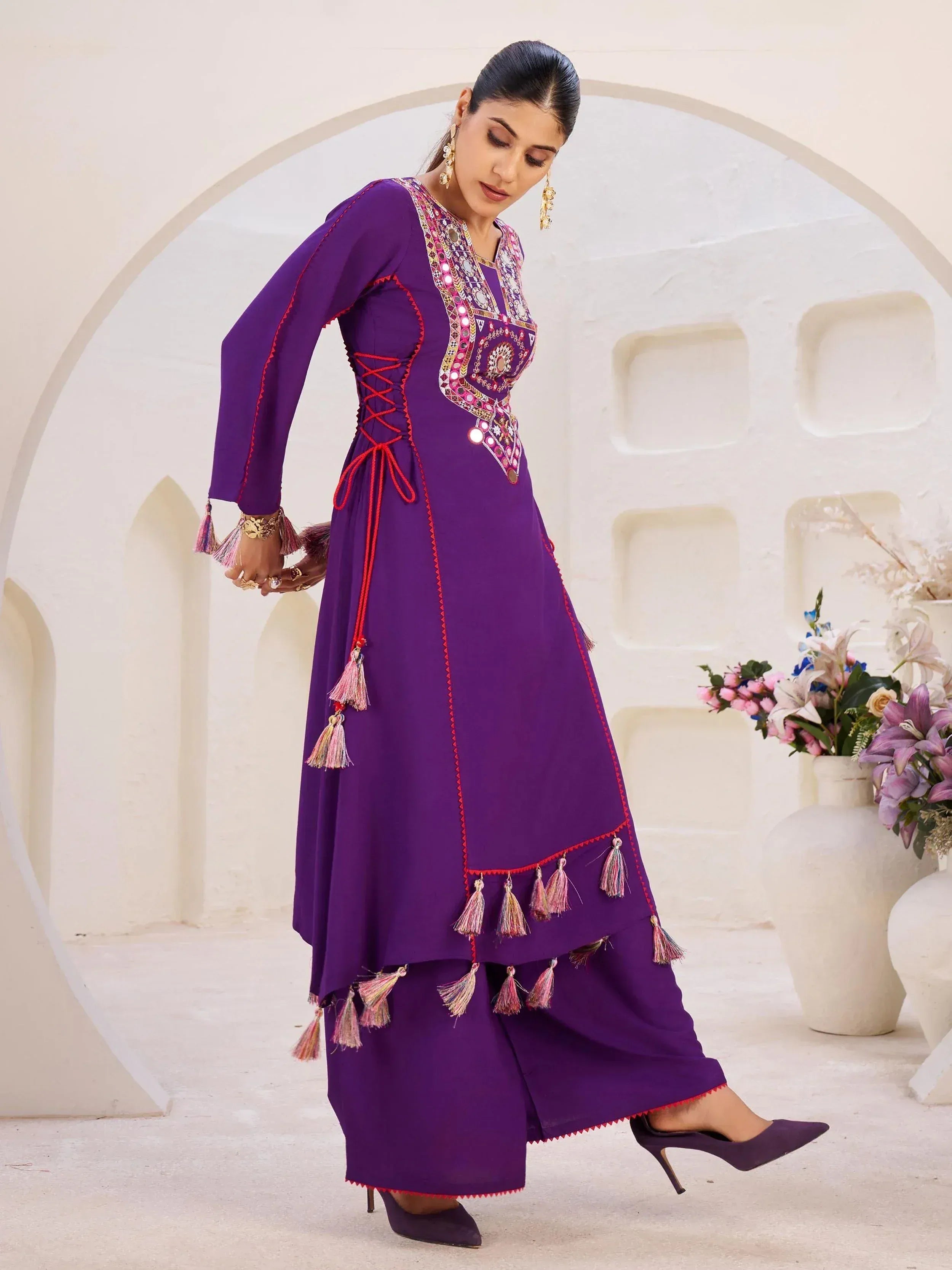 Purple ethnic anarkali suit with mirror work, tassels, and lace-up back, paired with palazzo pants