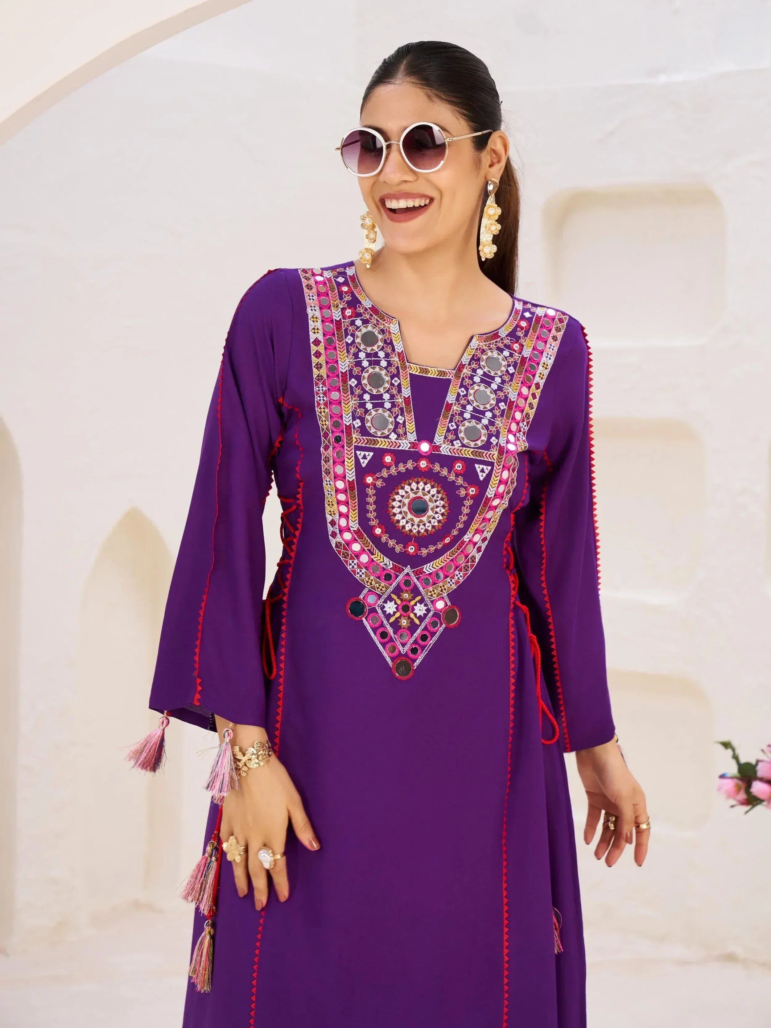 Purple ethnic kurti with mirror work and tassels, styled with sunglasses and gold jewelry