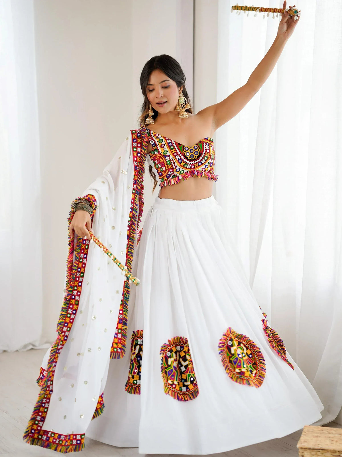 White ethnic lehenga choli with colorful mirror work, perfect for Indian festivals and celebrations