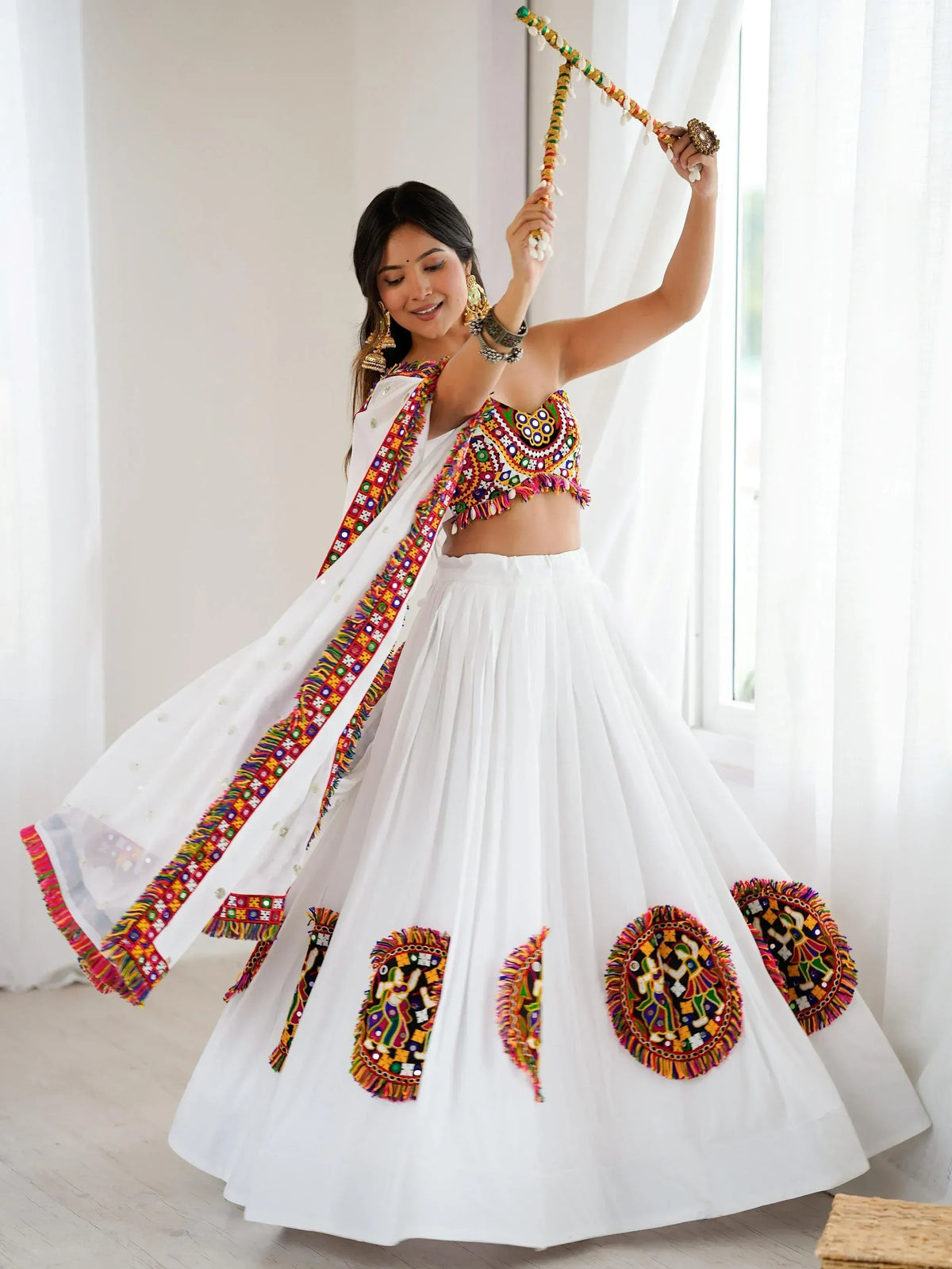 White ethnic lehenga choli with colorful mirror work, perfect for Indian festivals and celebrations.