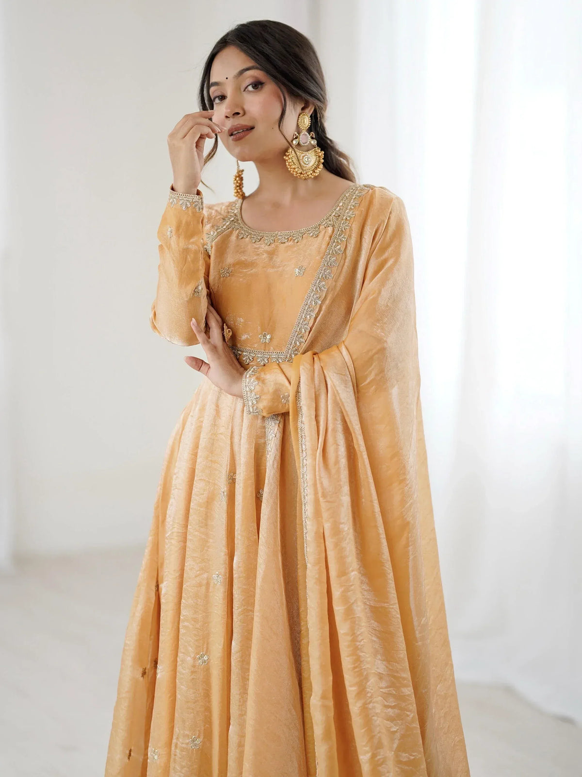 Elegant mustard yellow ethnic gown with floral embroidery and gold detailing, perfect for Indian celebrations