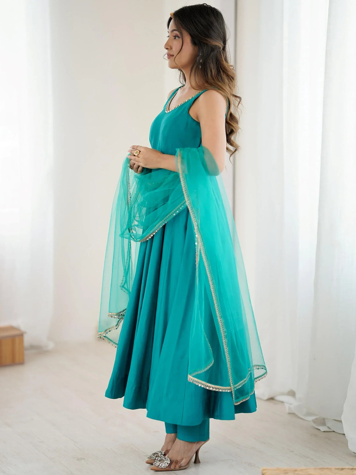 Teal ethnic anarkali suit with sheer dupatta, perfect for Indian weddings or festive occasions.