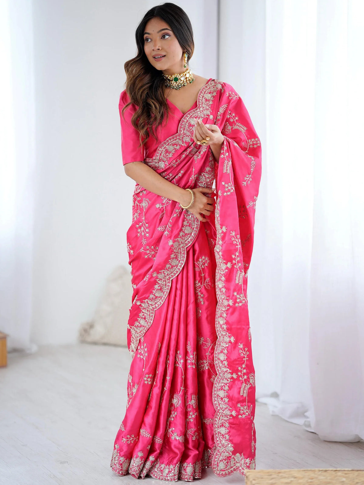 Woman wearing a pink designer saree with silver embroidery and ethnic jewelry