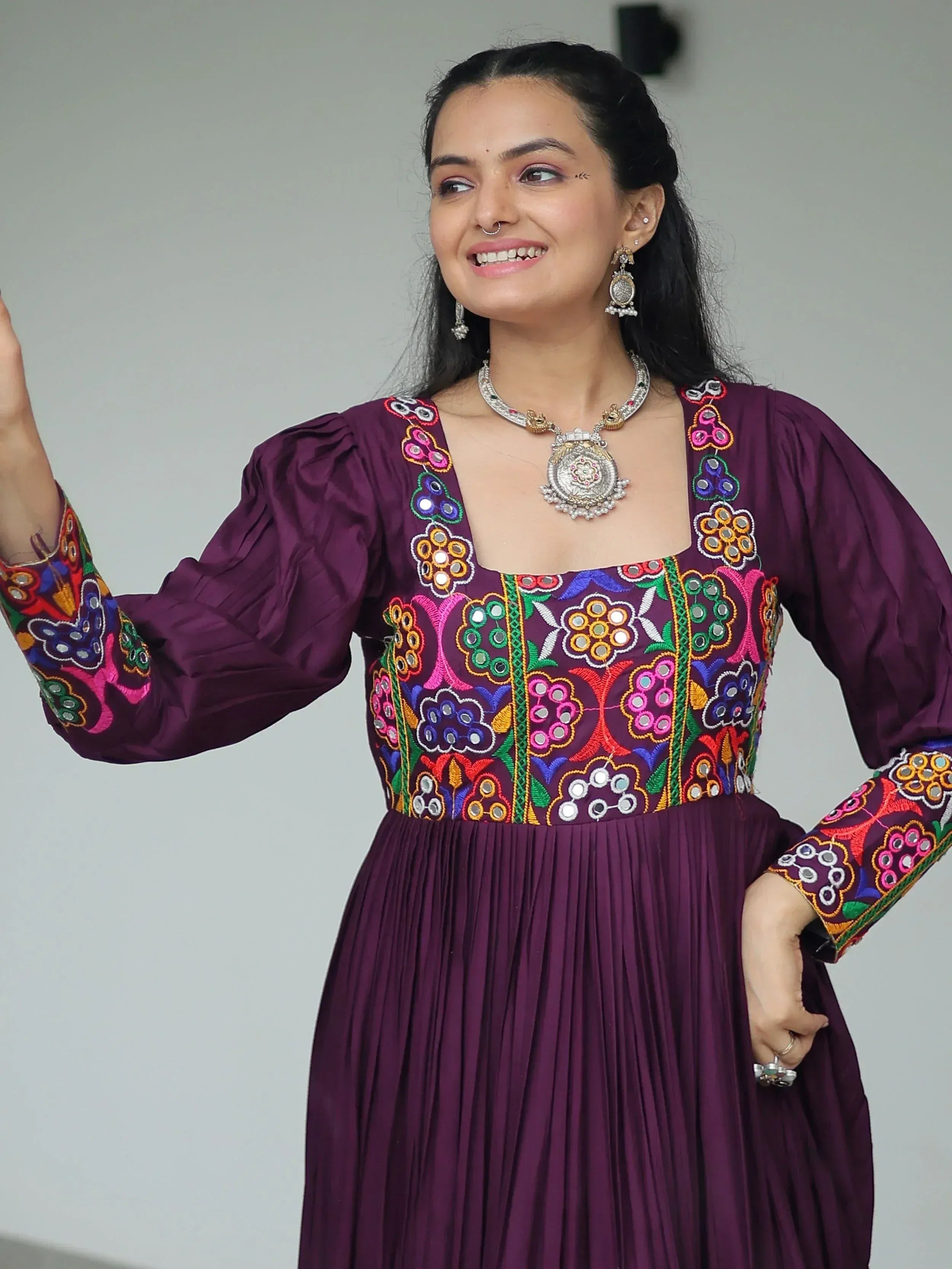Purple ethnic gown with colorful floral embroidery and traditional jewelry