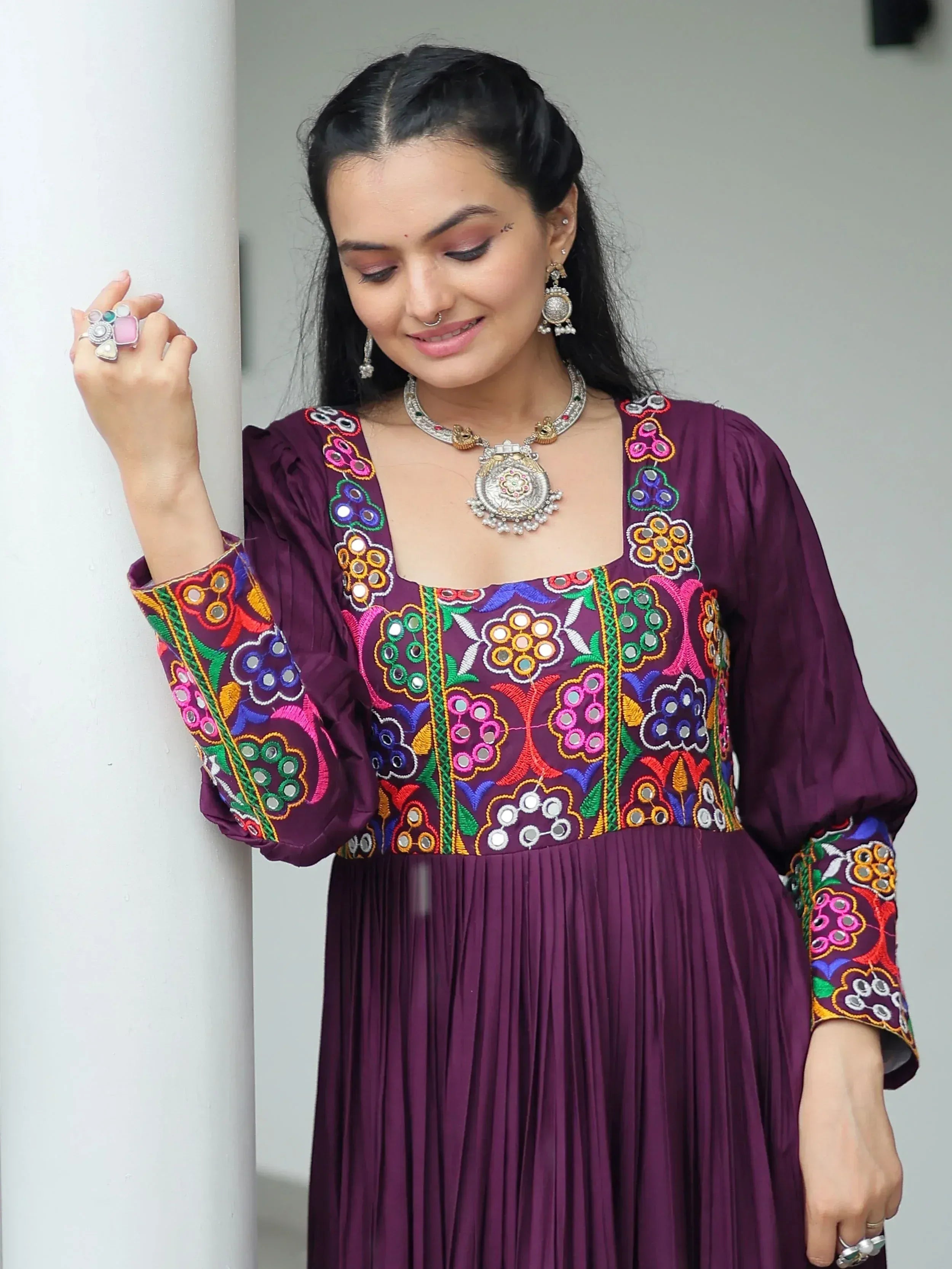 Purple ethnic gown with colorful mirror embroidery and traditional jewelry