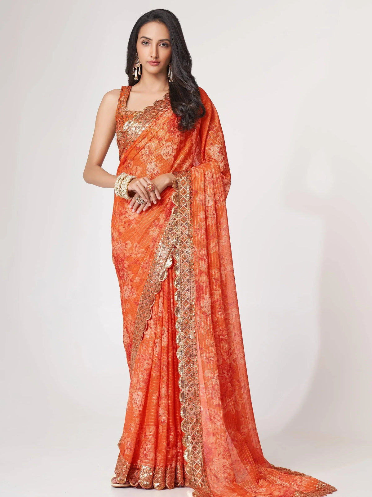 Orange floral saree with gold embroidery, perfect for Indian ethnic wear and festive occasions.