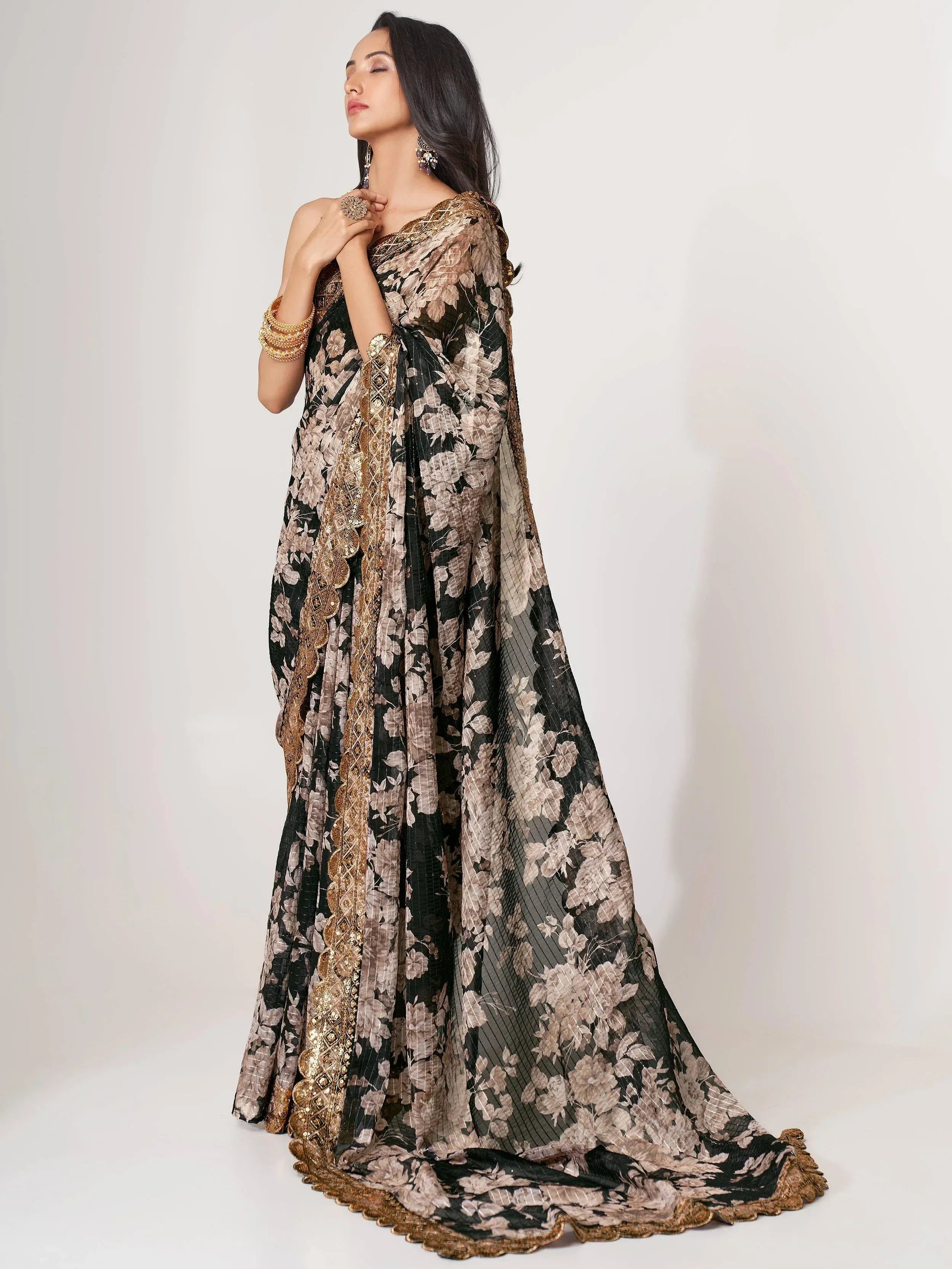 Elegant black and gold floral saree with intricate embroidery, perfect for Indian ethnic occasions.