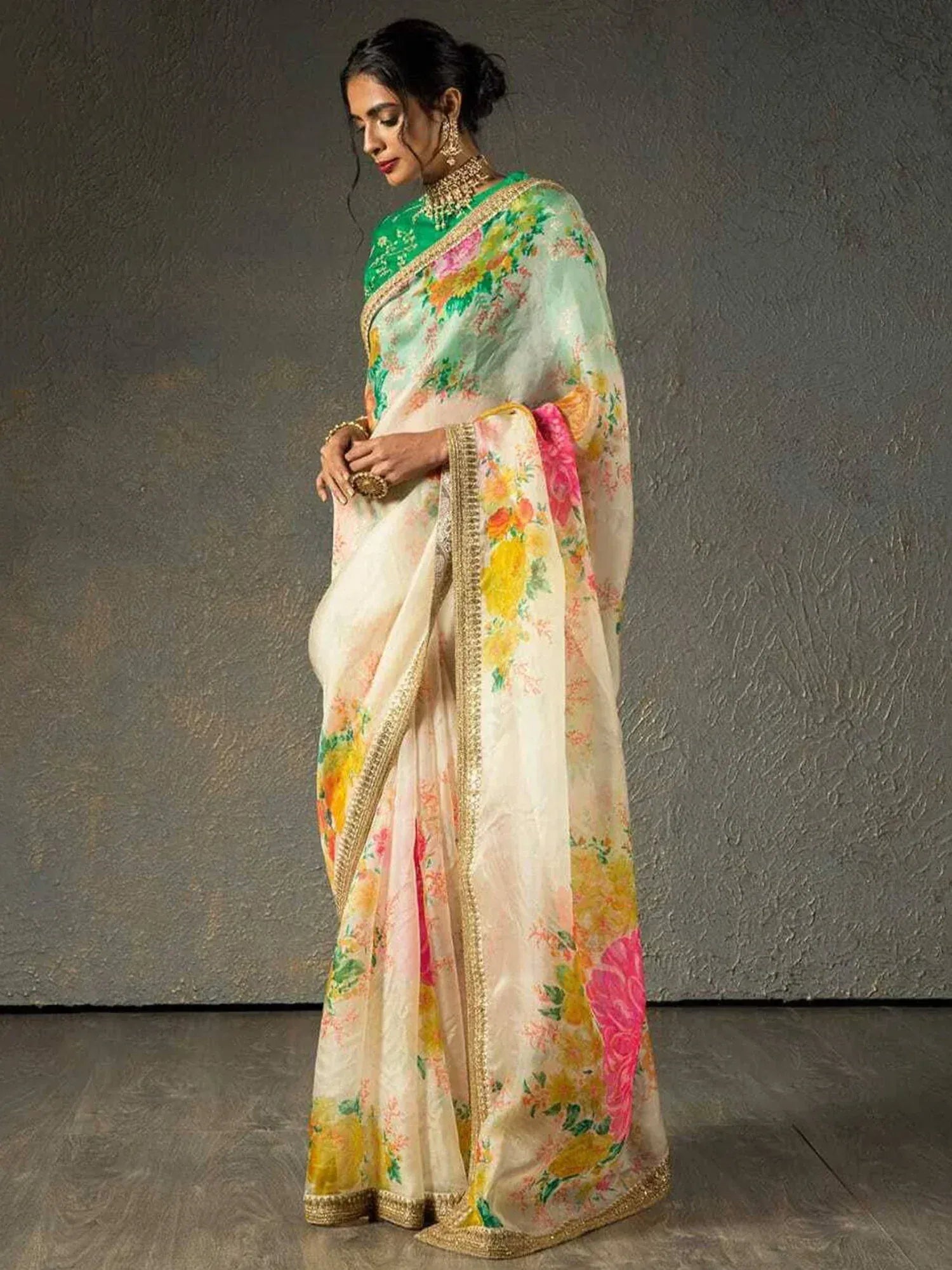 Elegant floral print saree with gold border, paired with green blouse, perfect for Indian ethnic occasions.