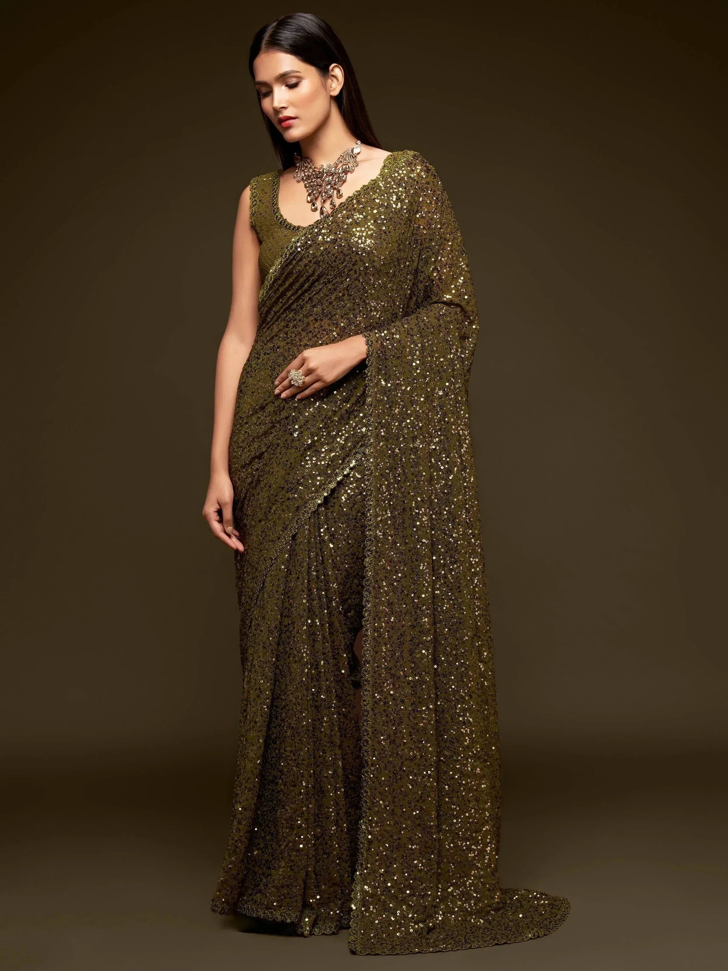 Olive green sequin saree with sleeveless blouse, perfect for Indian ethnic wear and festive occasions.