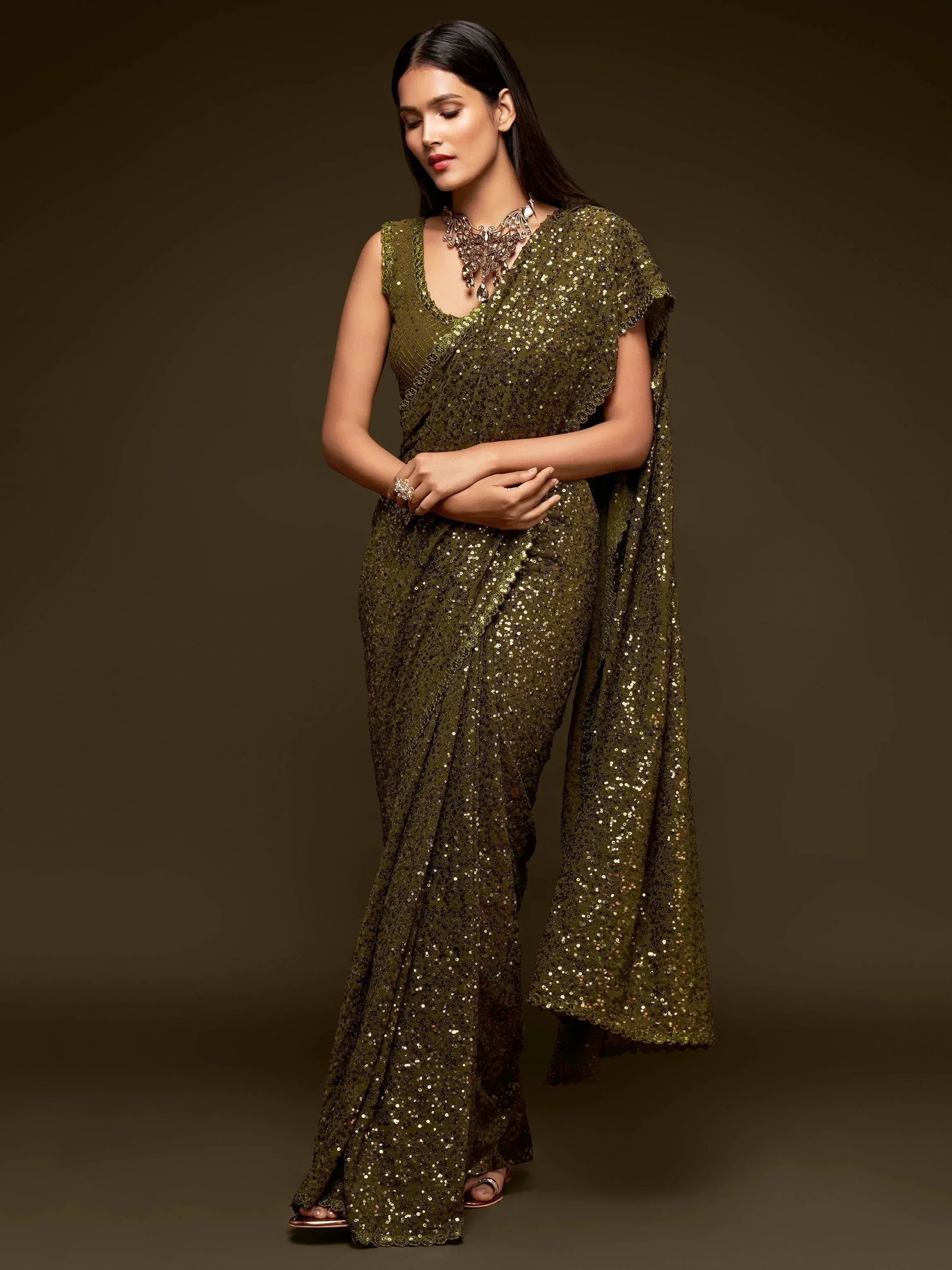 Olive green sequin saree with sleeveless blouse, perfect for Indian ethnic wear events and parties.