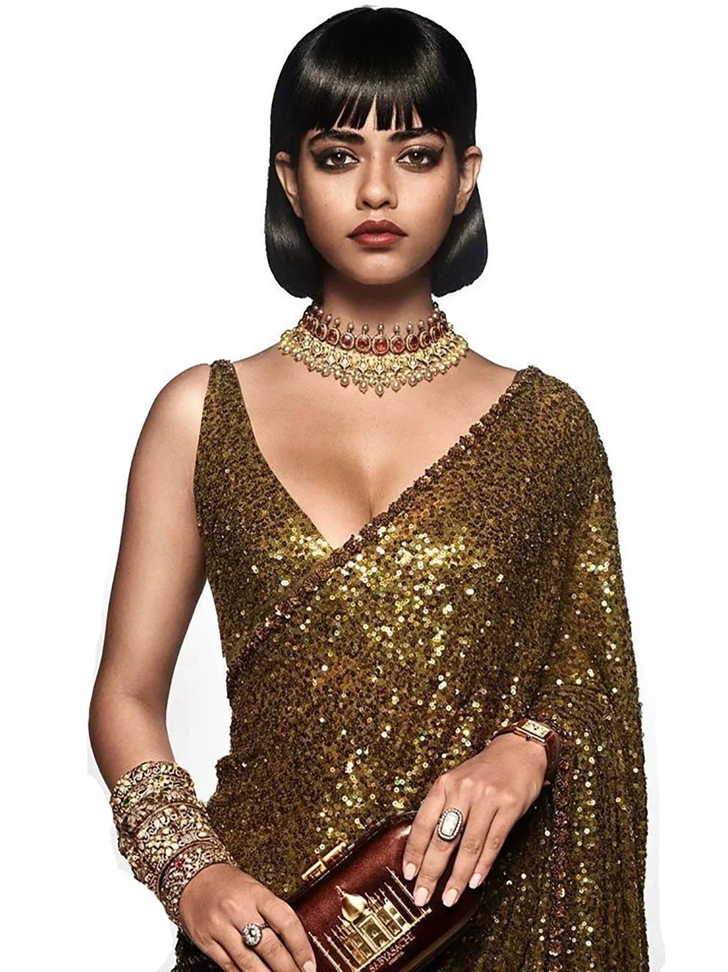 Woman in golden sequin saree with statement jewelry, perfect for Indian ethnic events and weddings.