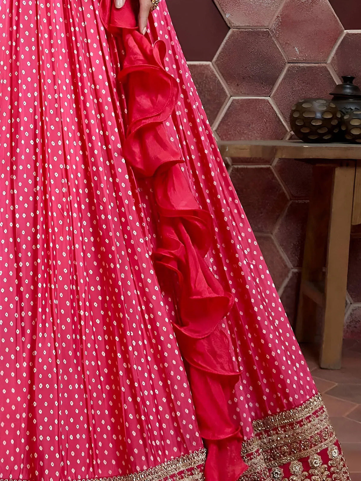Red printed lehenga with ruffle detailing and gold embroidery, perfect for Indian ethnic wear occasions.