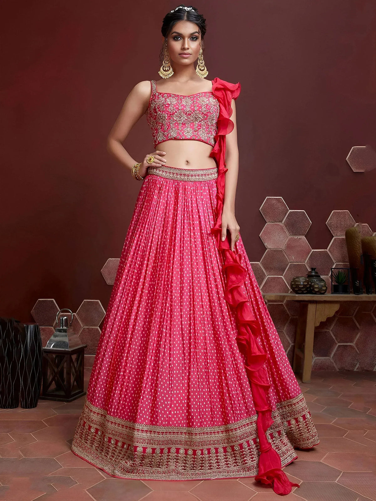 Pink designer lehenga choli with gold embroidery and ruffle detailing, perfect for Indian weddings and festive occasions.