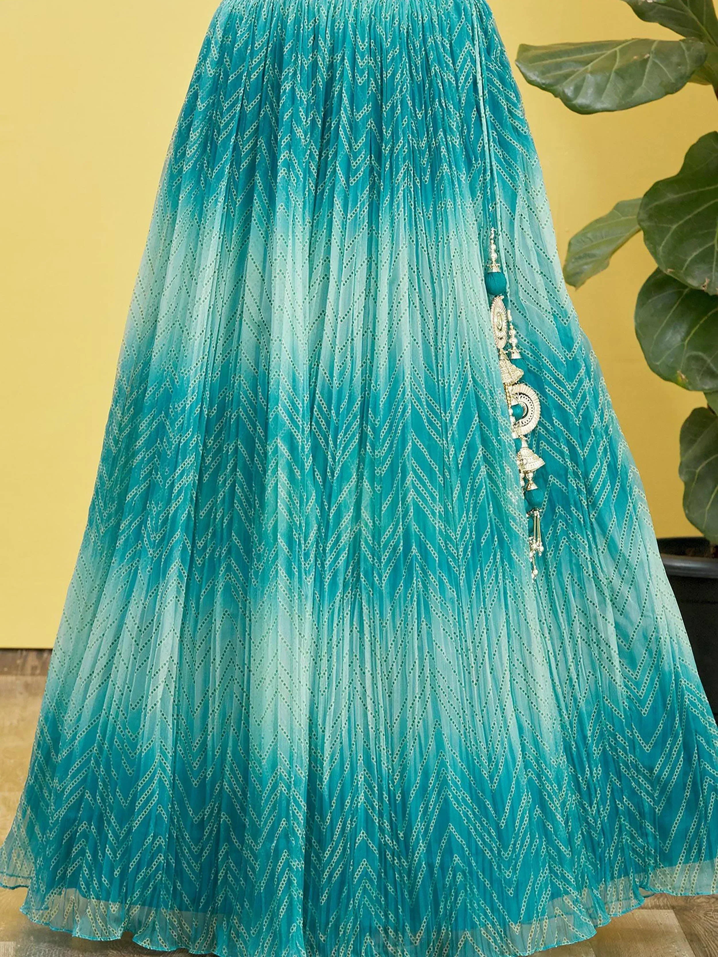 Turquoise ethnic lehenga skirt with zigzag print and tassel detail, perfect for Indian festive wear.