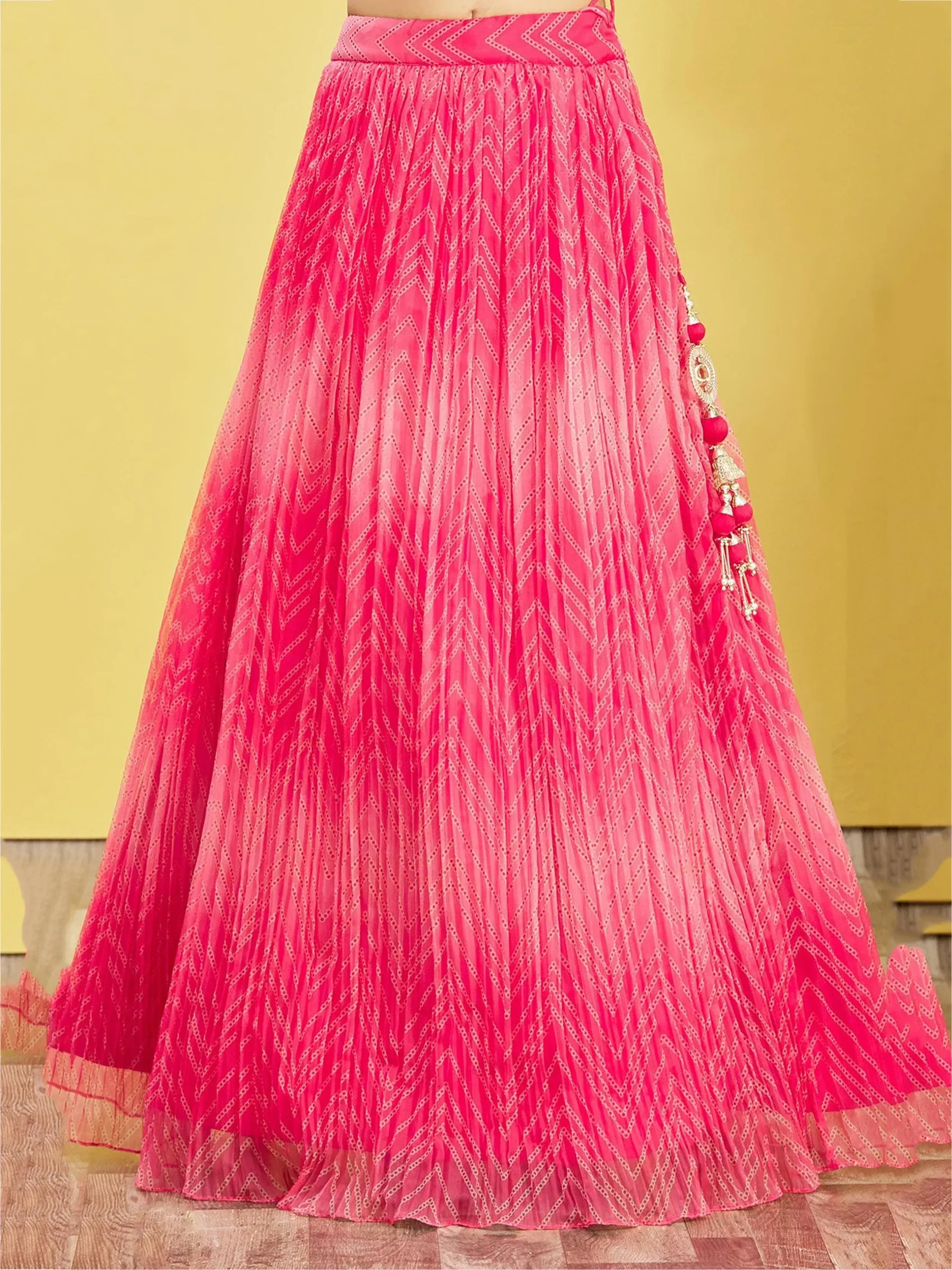 Pink pleated lehenga with zigzag print and tassel detailing, ideal for Indian ethnic wear