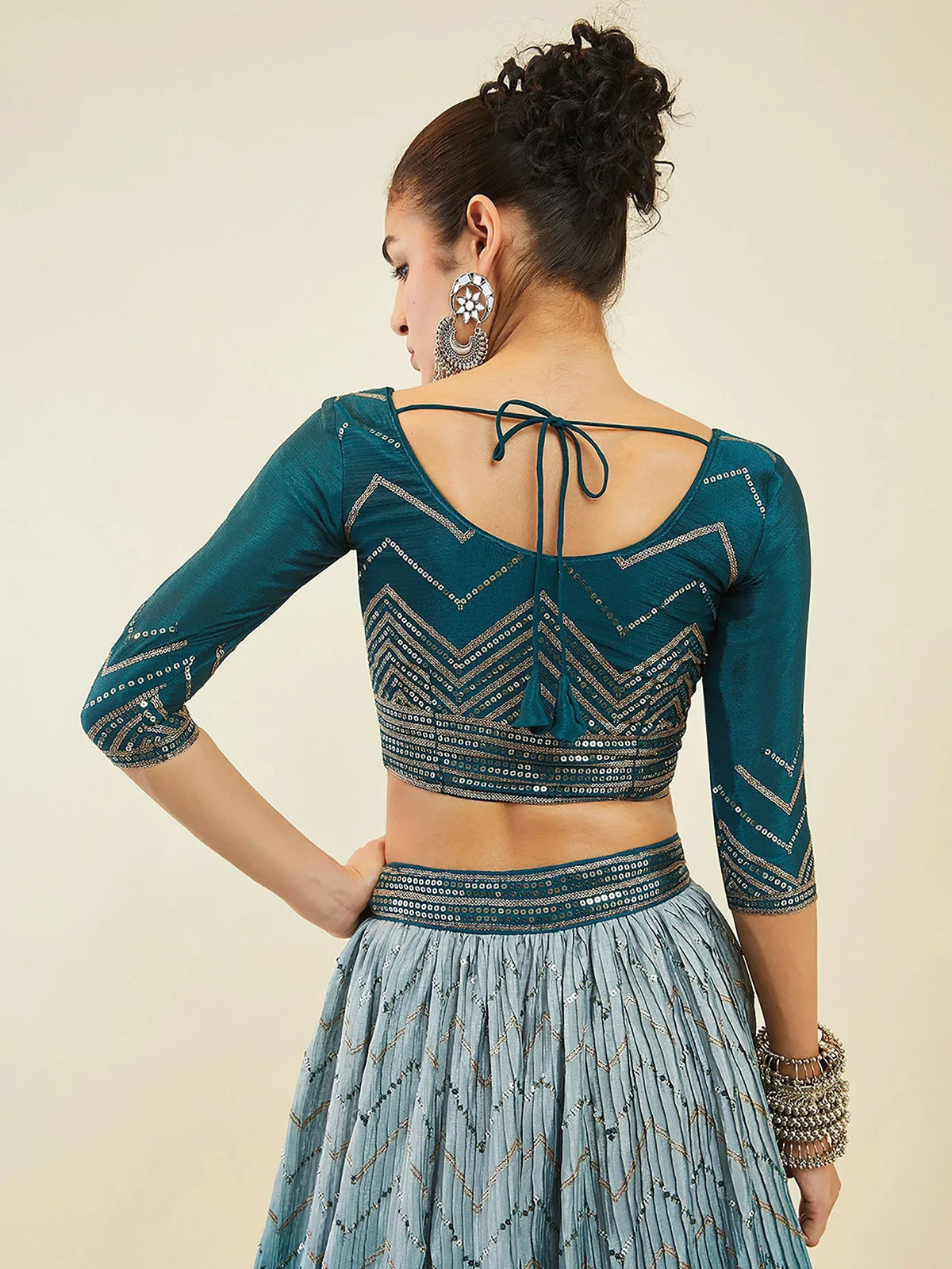 Teal ethnic lehenga choli with back tie blouse and pleated skirt, perfect for Indian weddings or parties.