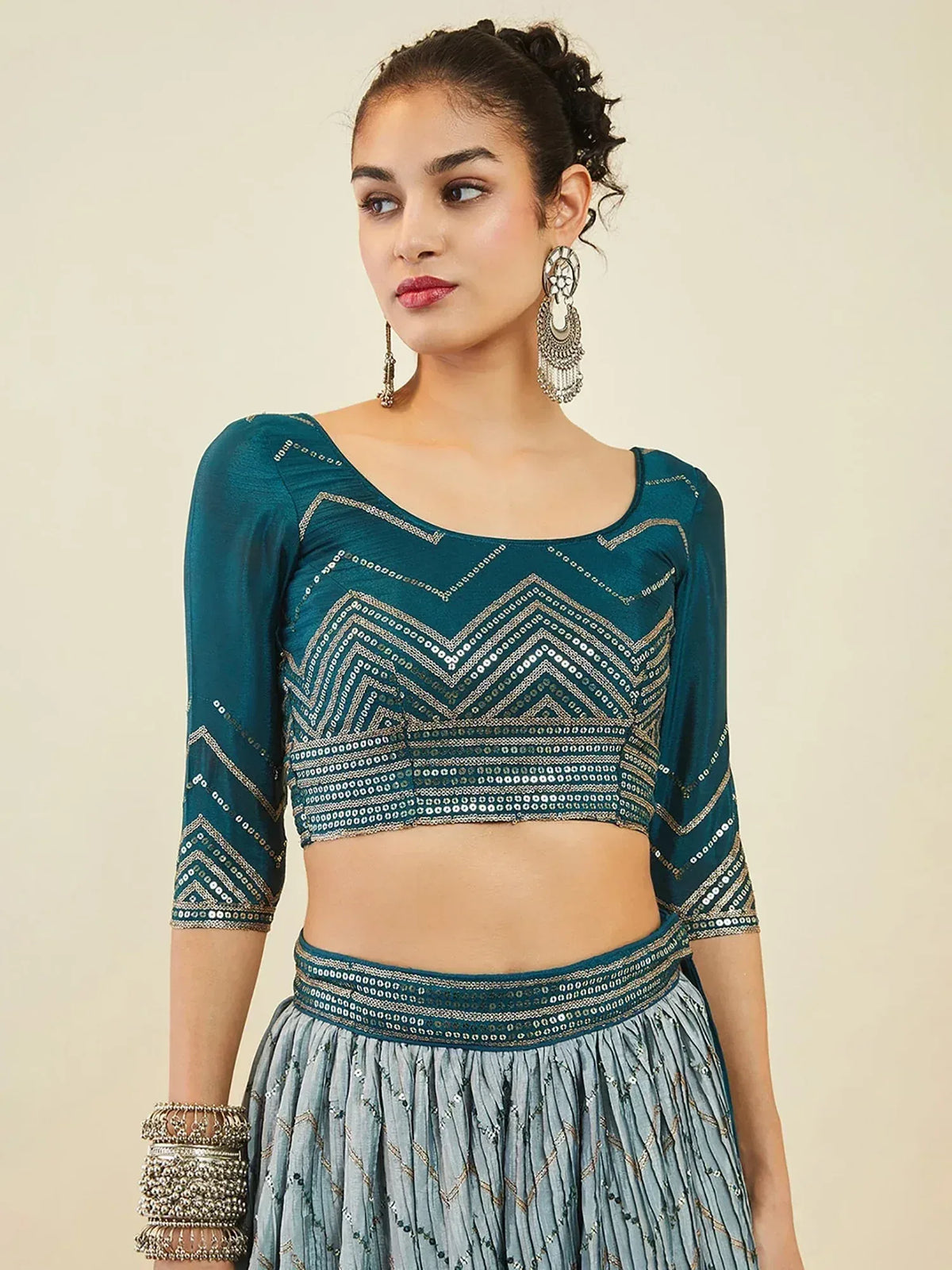Teal embroidered lehenga choli with gold chevron detailing, perfect for Indian ethnic wear occasions.