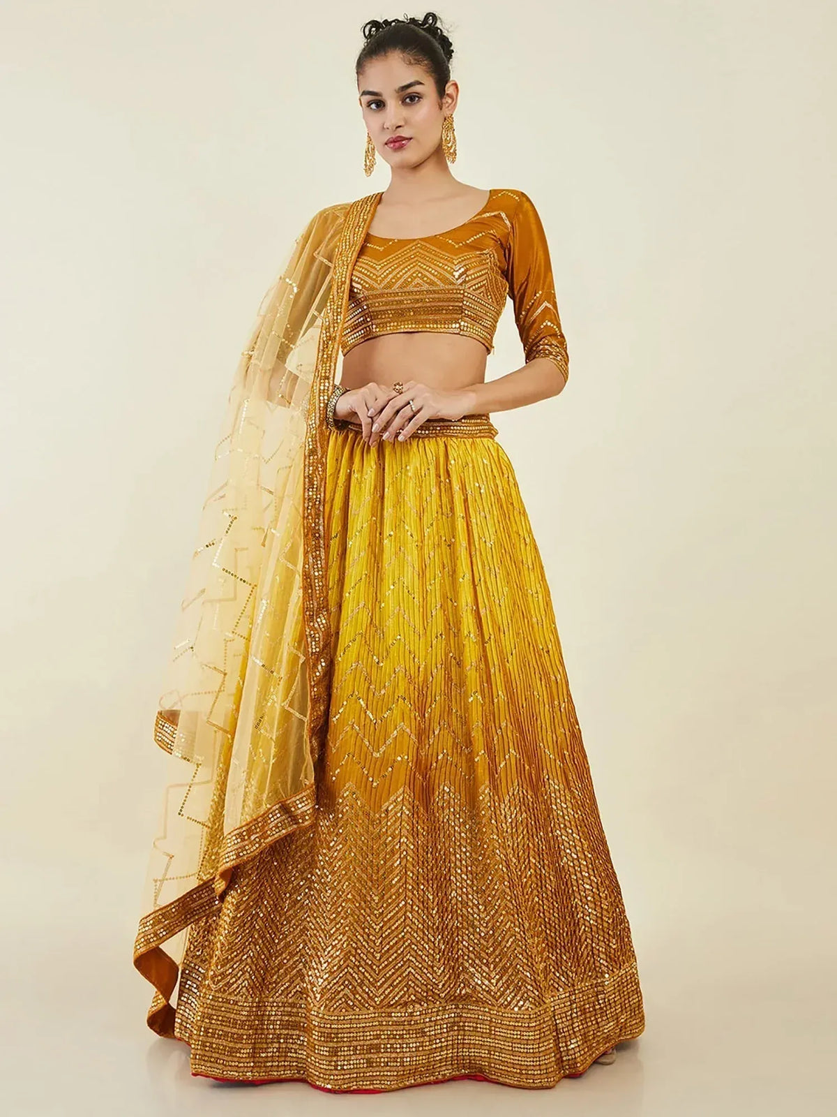 Golden embroidered lehenga choli with sheer dupatta, perfect for Indian weddings and festive occasions