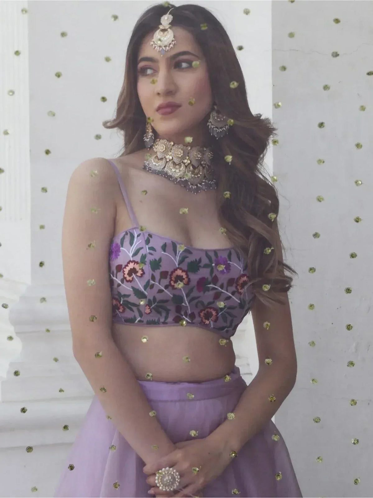 Purple floral embroidered lehenga choli with gold jewelry, perfect for Indian ethnic wear events.