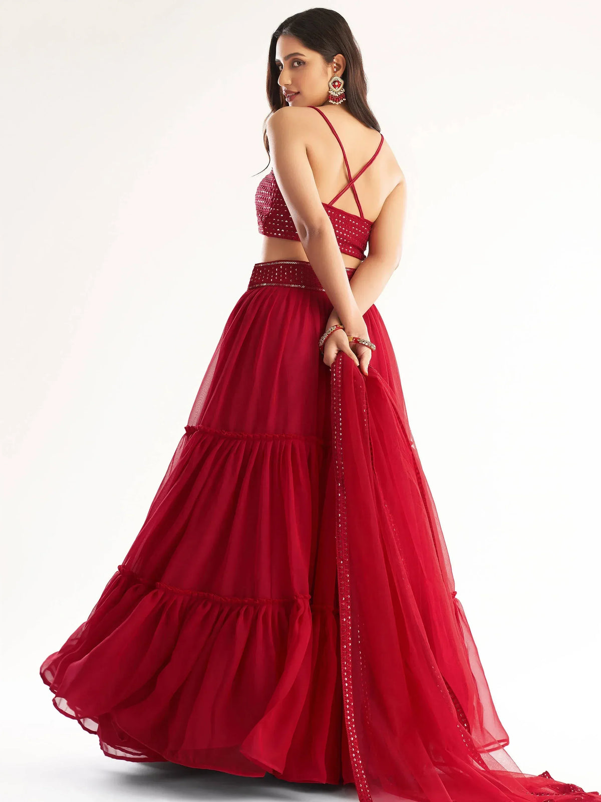 Red designer lehenga choli with sequin embellishments, criss-cross back top, and layered tulle skirt for Indian ethnic wear