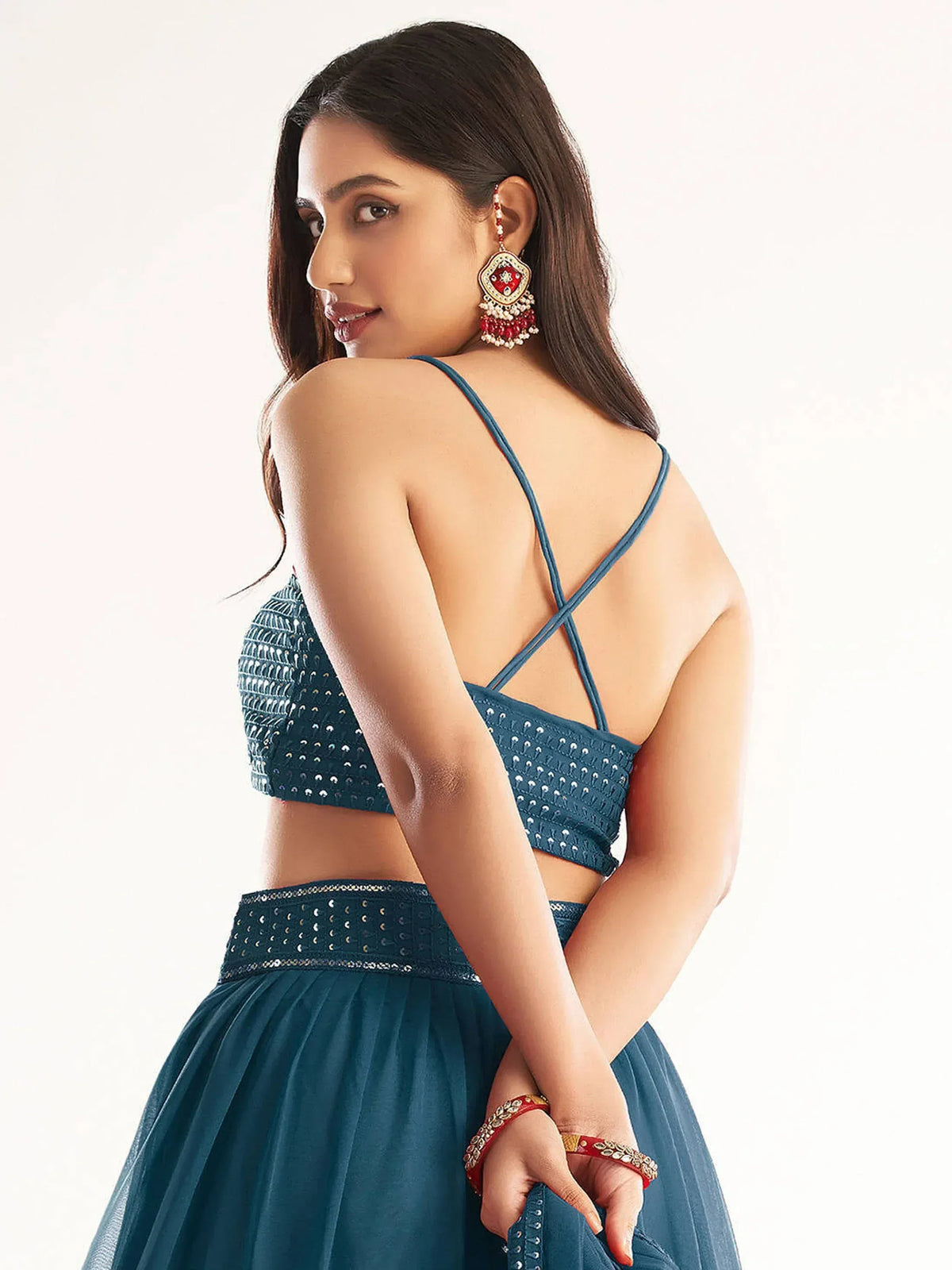 Teal blue lehenga choli with backless blouse, mirror work, and statement earrings for Indian ethnic wear