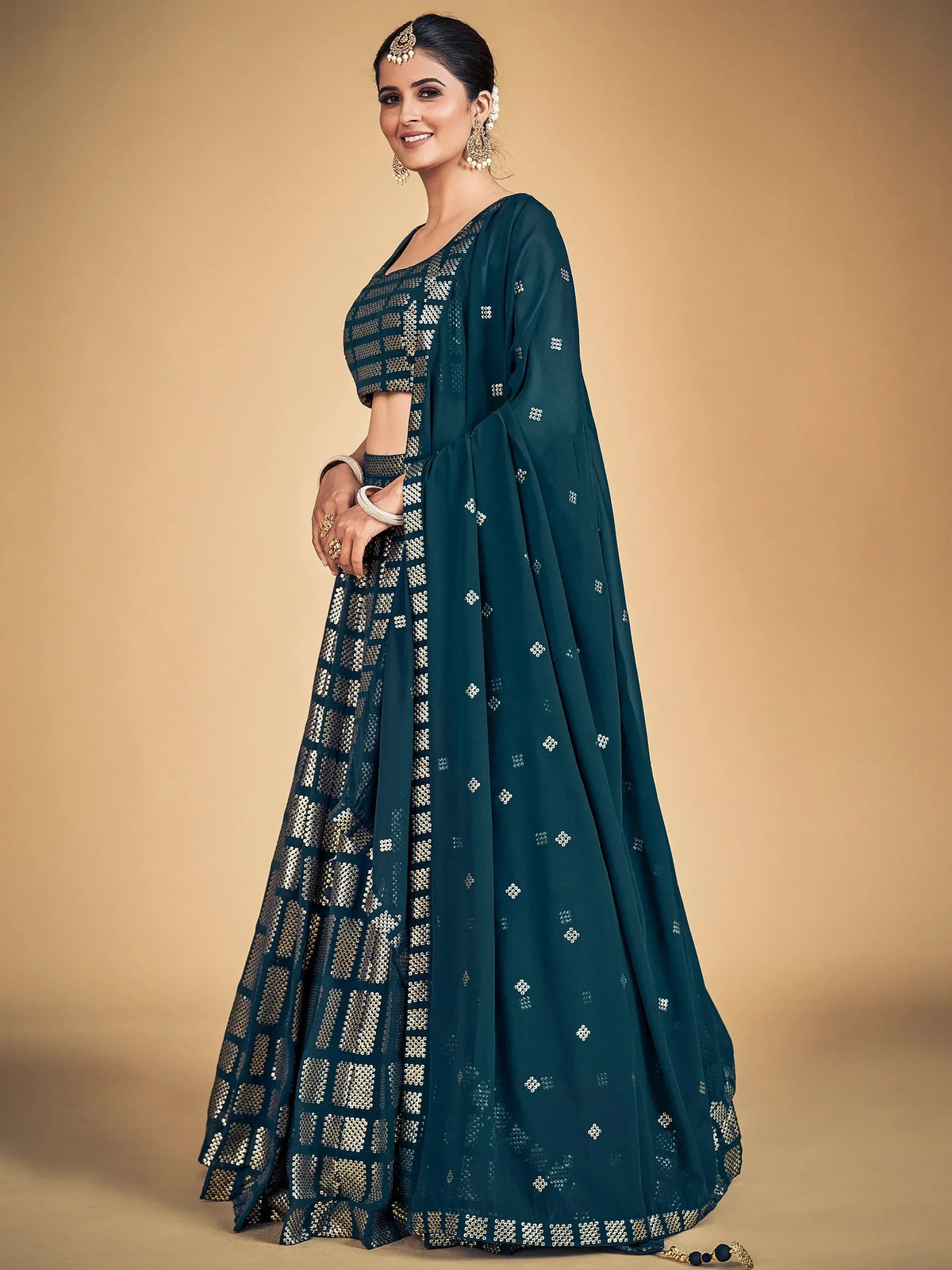 Teal designer lehenga choli with gold sequin embroidery, perfect for Indian ethnic wear occasions.