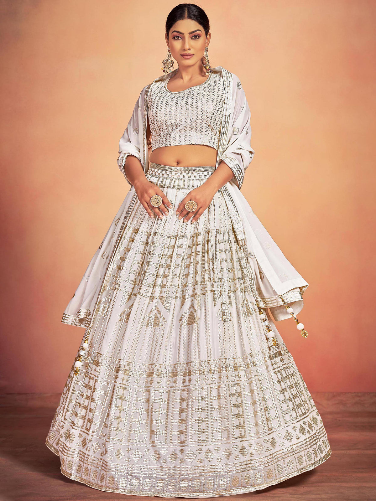 Elegant white and gold embroidered lehenga choli with intricate patterns and dupatta