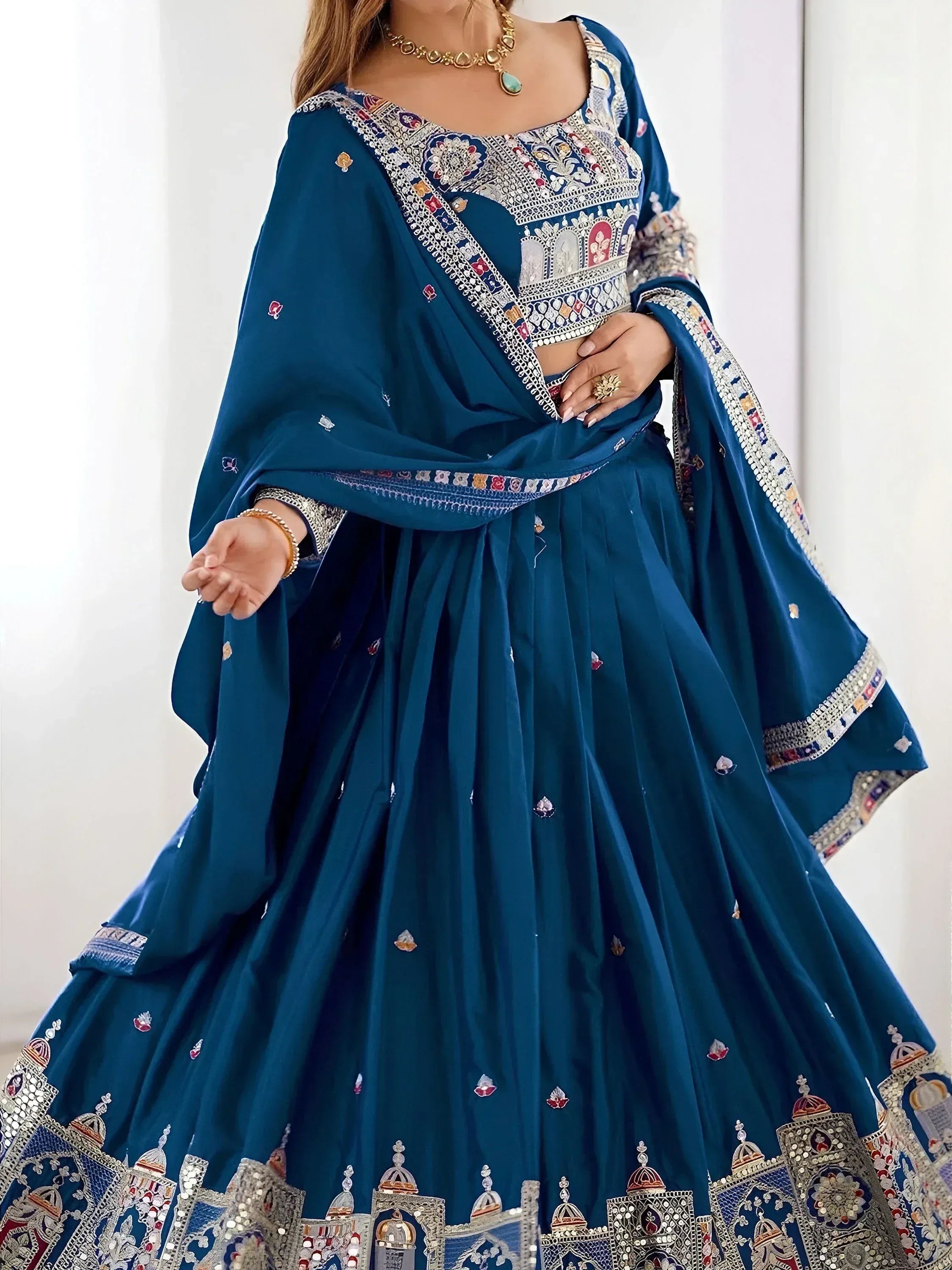 Teal blue designer lehenga choli with intricate mirror and thread embroidery, perfect for Indian ethnic wear.