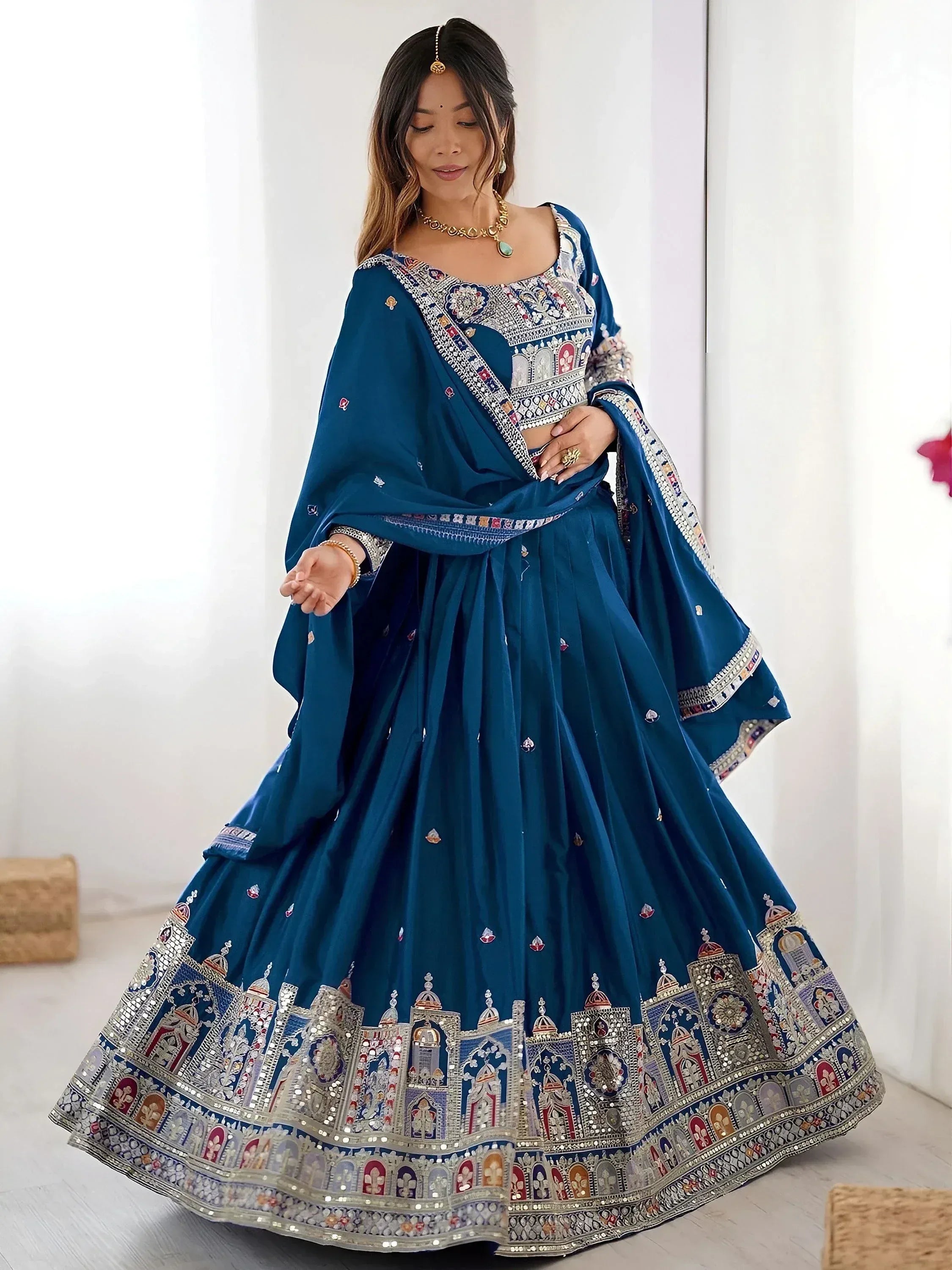 Blue designer lehenga choli with intricate temple embroidery and mirror work, perfect for Indian ethnic occasions.